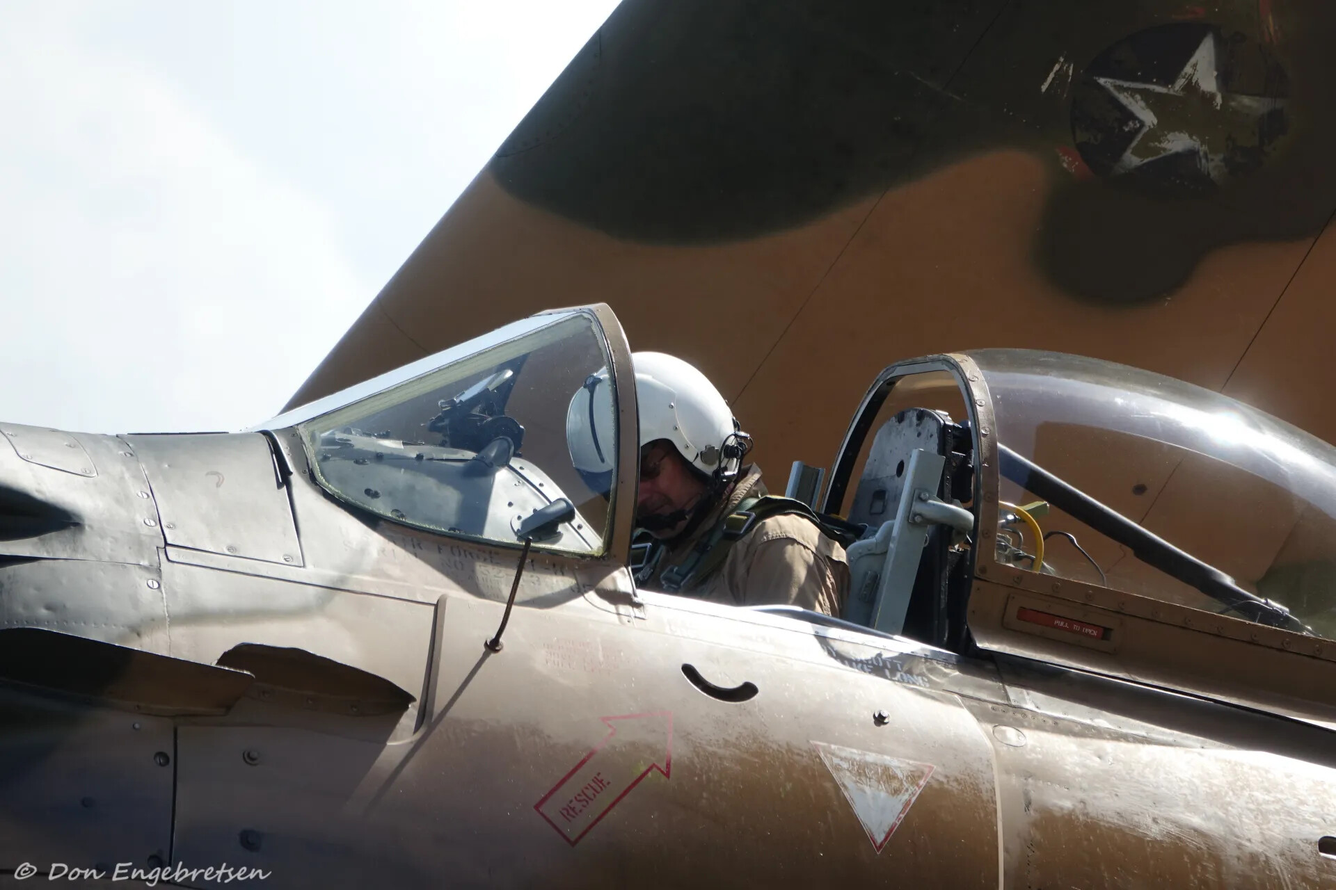 A-1 Skyraider Pilot in Cockpit with White Flight Helmet, Serial '52-3...' Visible (Watermarked)
