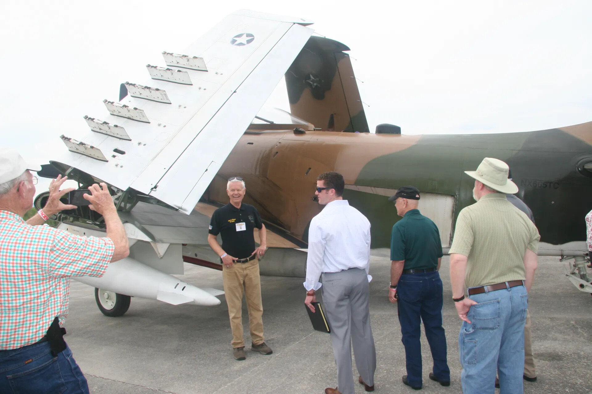 Veterans Group Examining Restored A-1 Skyraider on Airfield Ramp