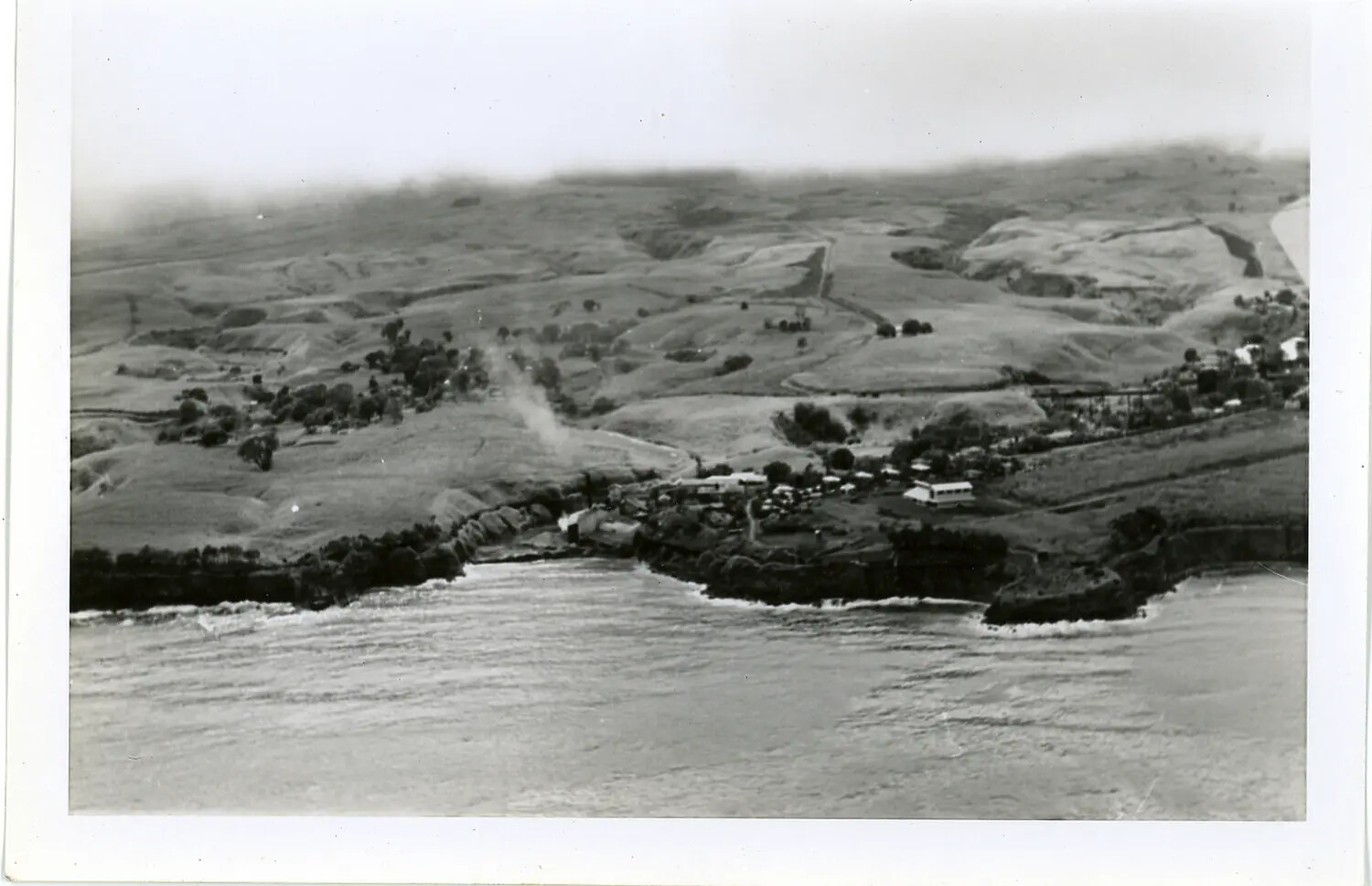 Aerial View of a Rural Hawaiian Coastline with Small Settlement and Sea Cliffs
