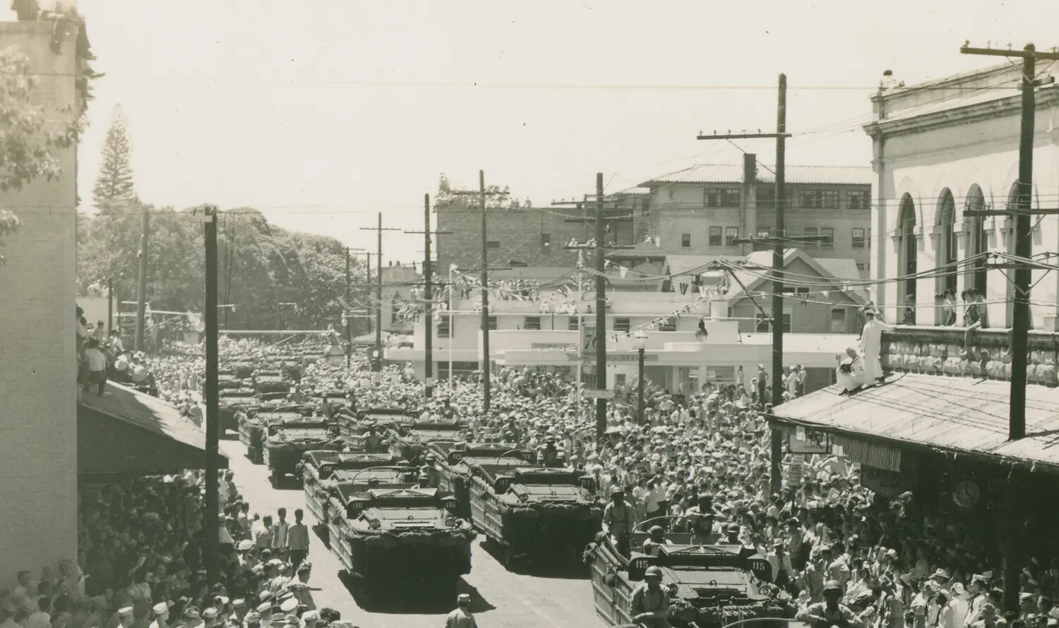 DUKW Amphibious Truck Column Passing Through Crowded Honolulu Street During VJ Day Celebrations, 1945