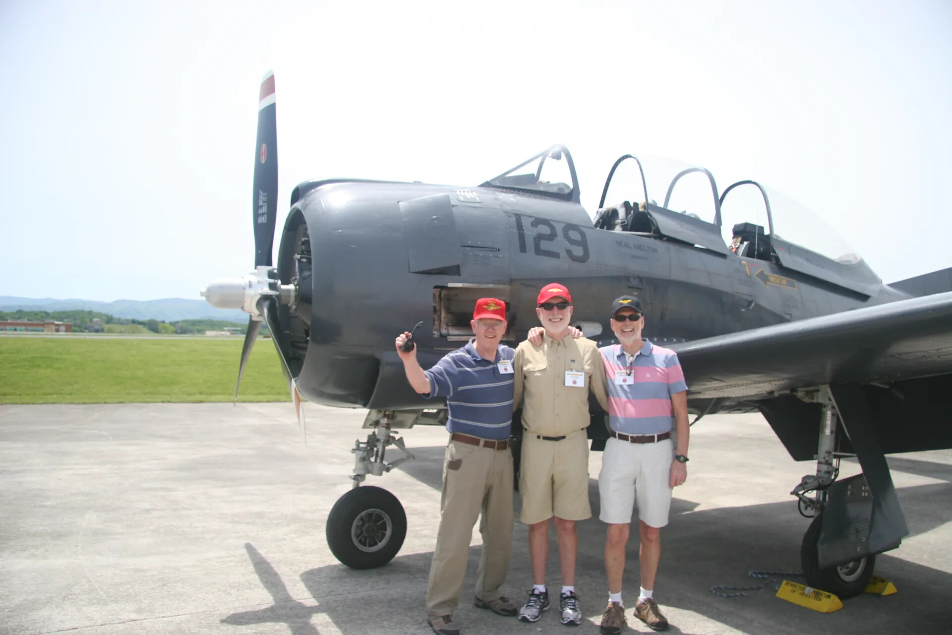 Three Reunion Attendees Pose Before T-28 "129 / Neal Melton" at the Tennessee Museum of Aviation (Third Frame)
