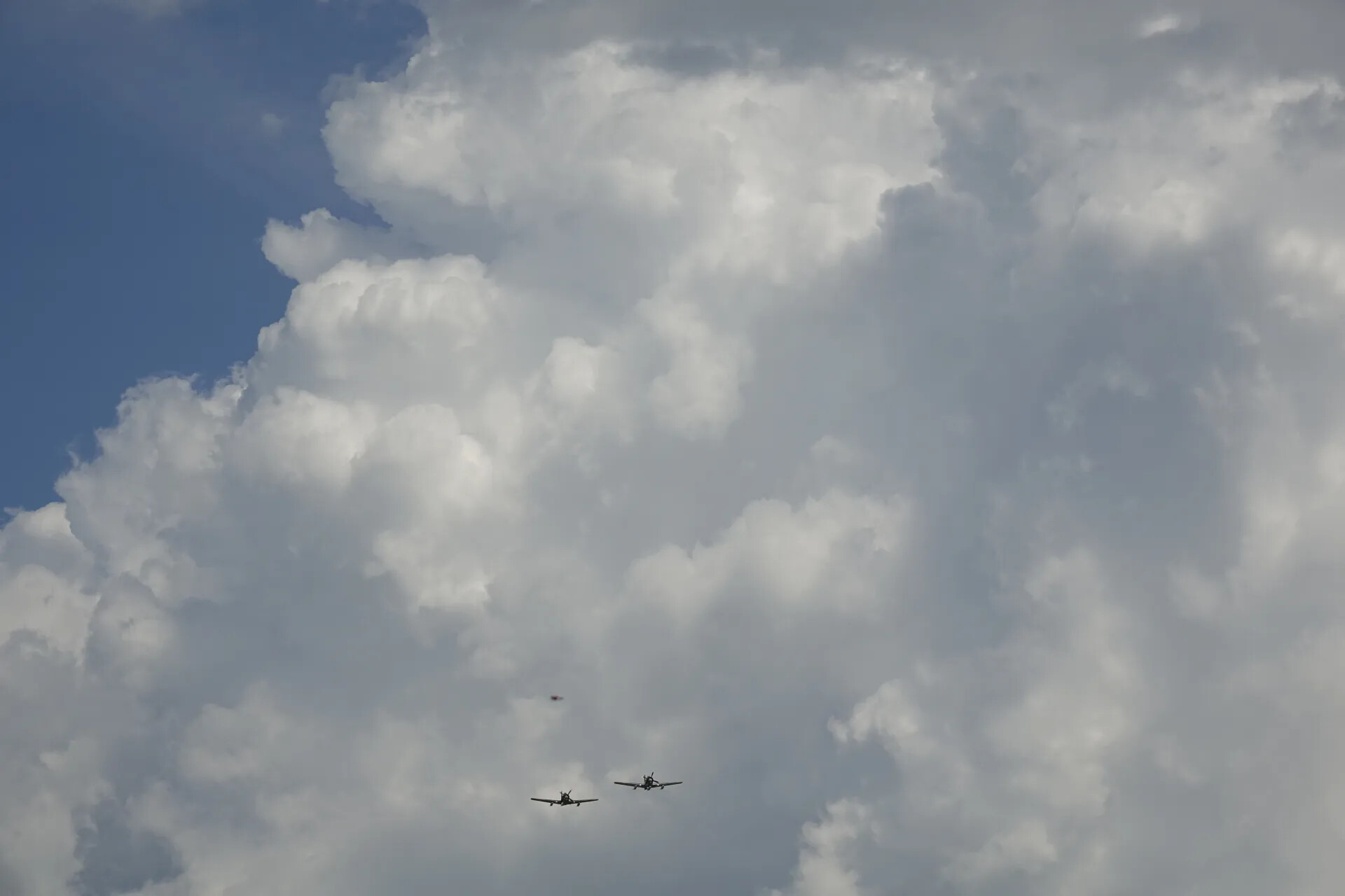 Two Aircraft in Formation Beneath Cumulus Clouds, May 2019 Fly-In Event