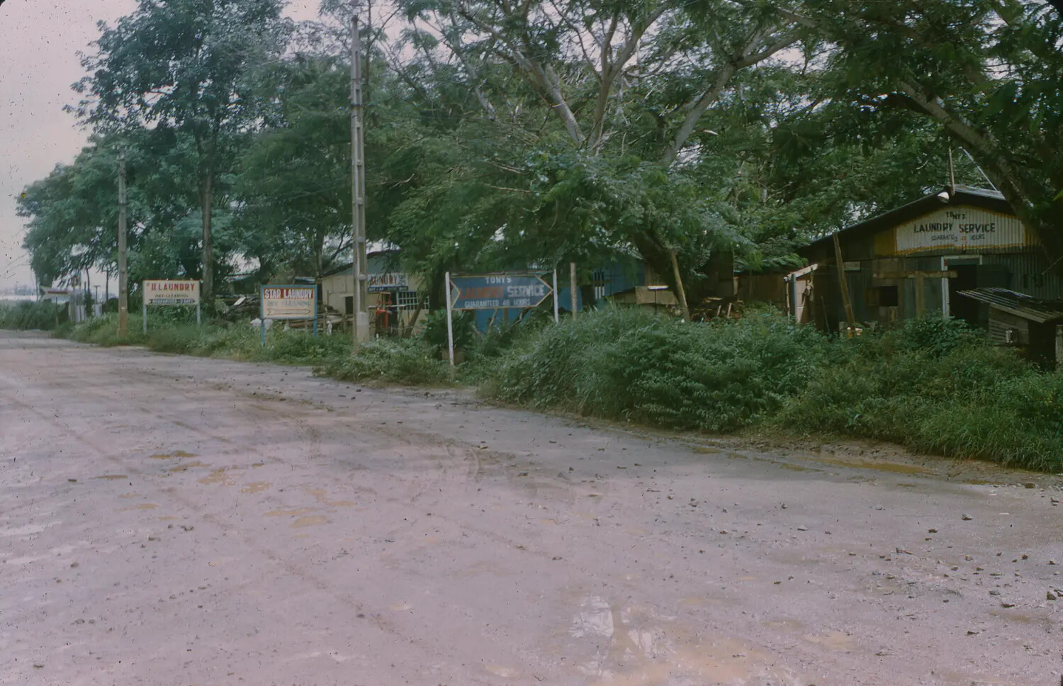 Local Laundry Shops Along Dirt Road Near U.S. Air Base, South Vietnam, 1965