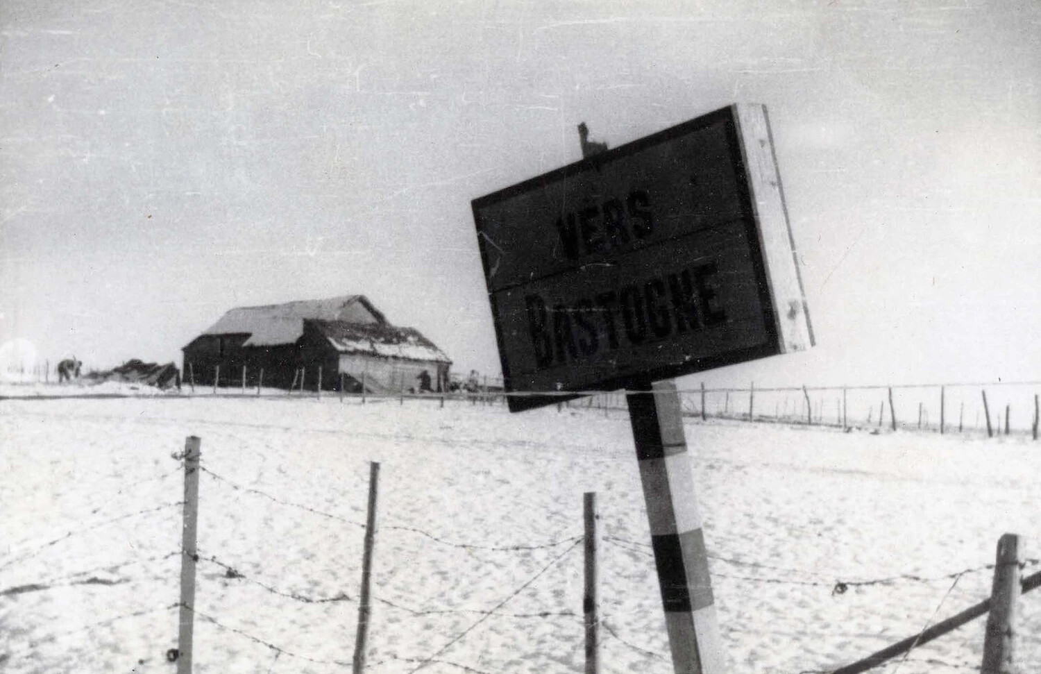 Road Sign 'VERS BASTOGNE' in Snow-Covered Ardennes Landscape, Battle of the Bulge, WWII
