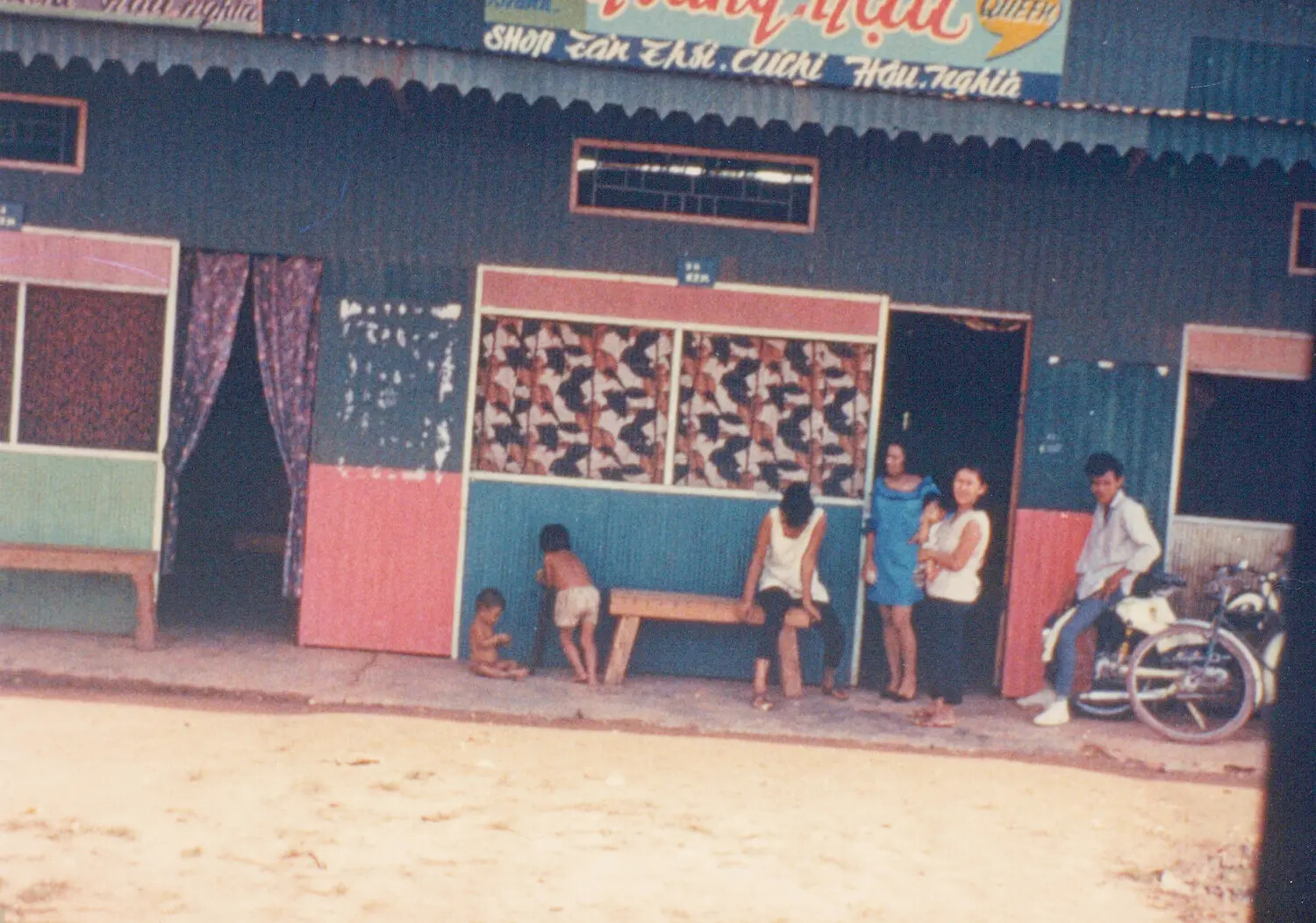 Street Scene with Vietnamese Family and Shopfront, Cu Chi, Hau Nghia Province, South Vietnam, 1967