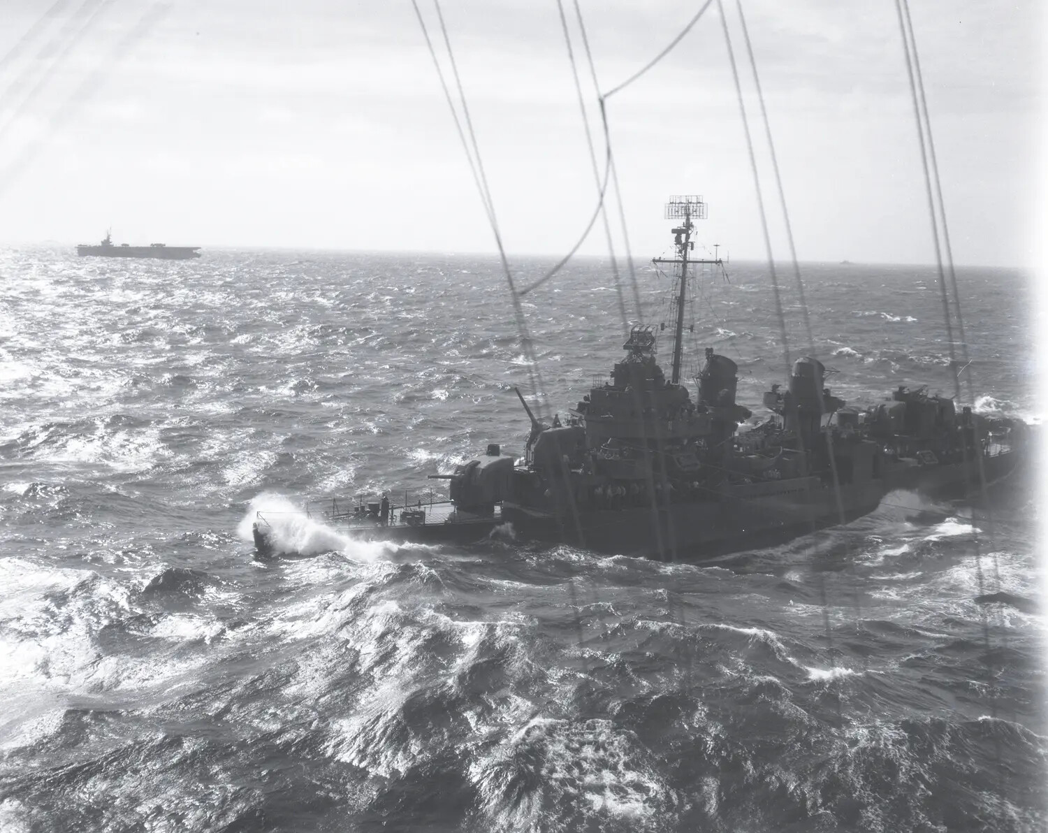 US Navy Destroyer Underway in Heavy Seas, Photographed from USS Petrof Bay (CVE-80)