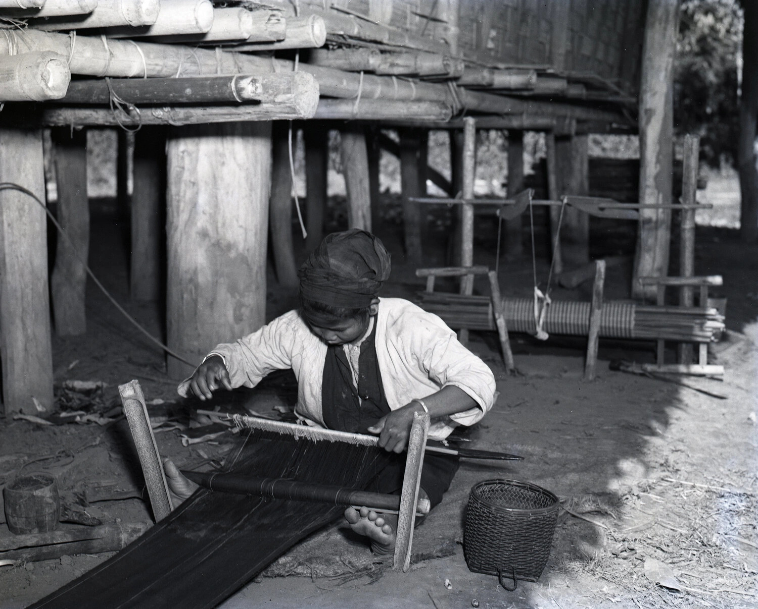 Woman Weaving Cloth on Backstrap Loom Beneath Stilt House, China-Burma-India Theater, WWII