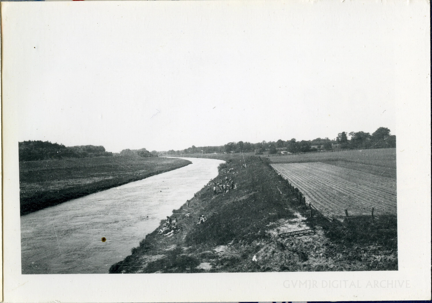 Soldiers Resting Along a River Bank in European Farmland, WWII