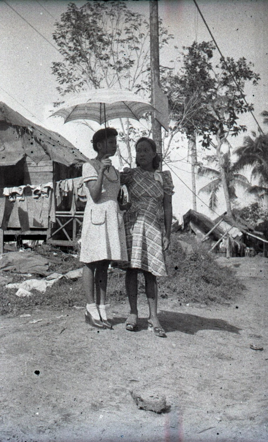 Two Young Women with Parasol in Village Setting, Luzon, Philippines, WWII Era