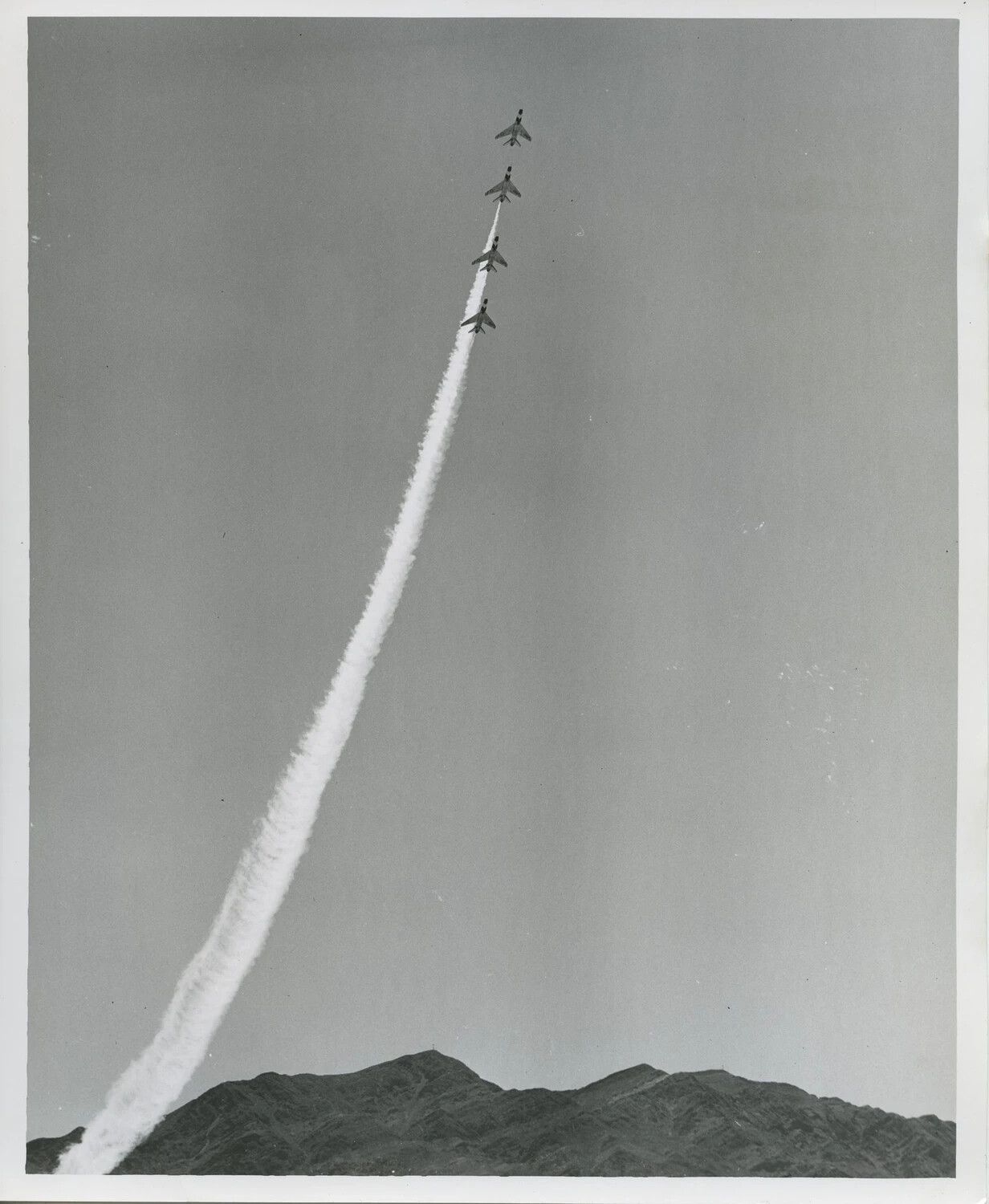 Four Jets in Line-Astern Formation Climbing Vertically Over Mountains