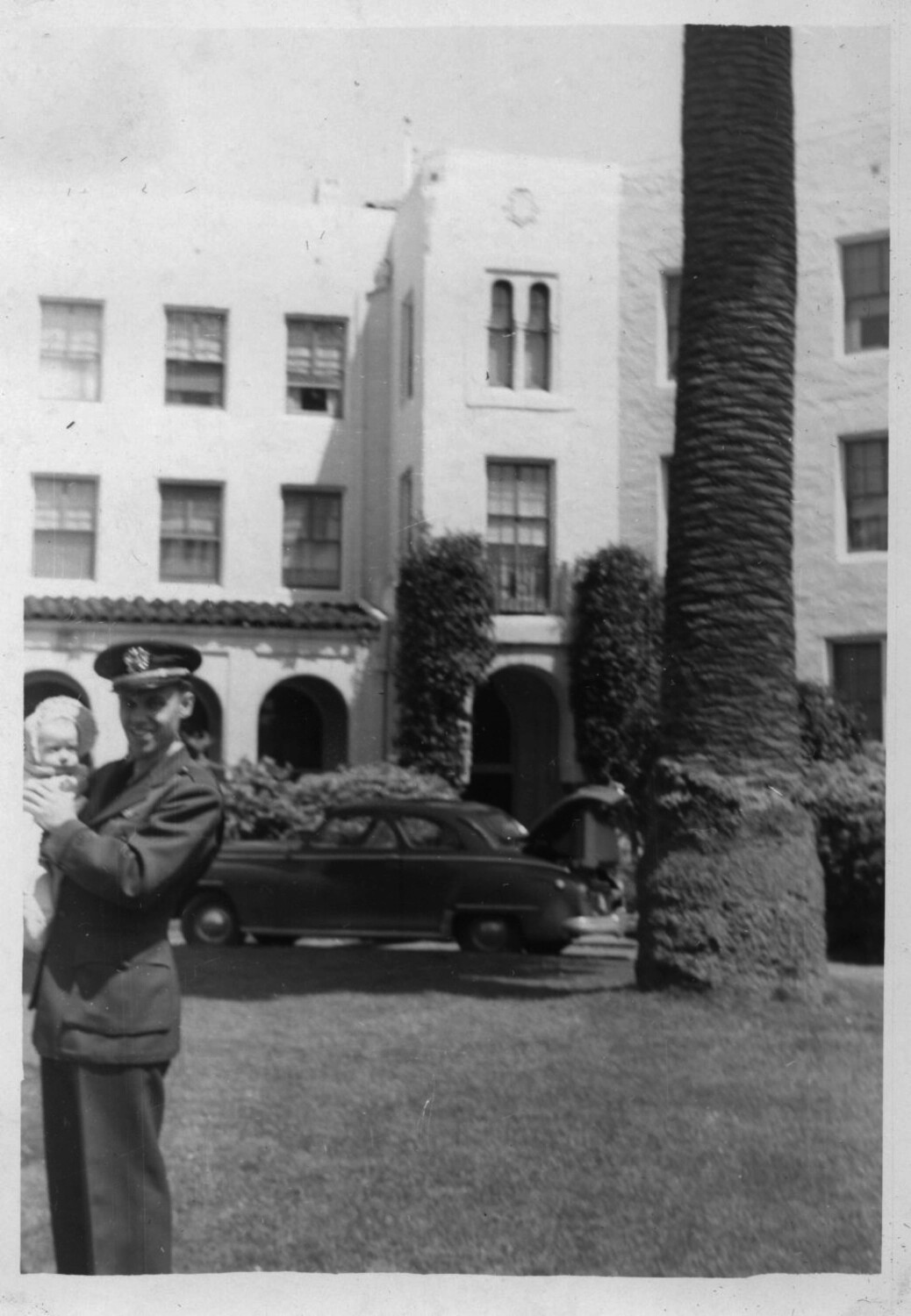 U.S. Navy Officer in Service Dress Blue Holding Infant Child, Outside Spanish Colonial Revival Apartment Building
