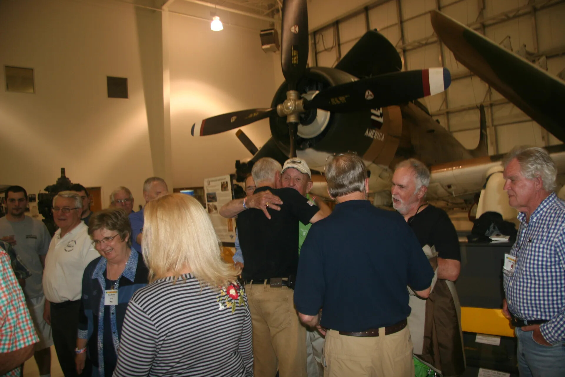 Veterans Embrace at Operation Tailwind Reunion, Beneath Static-Display A-1 Skyraider, April 30, 2016