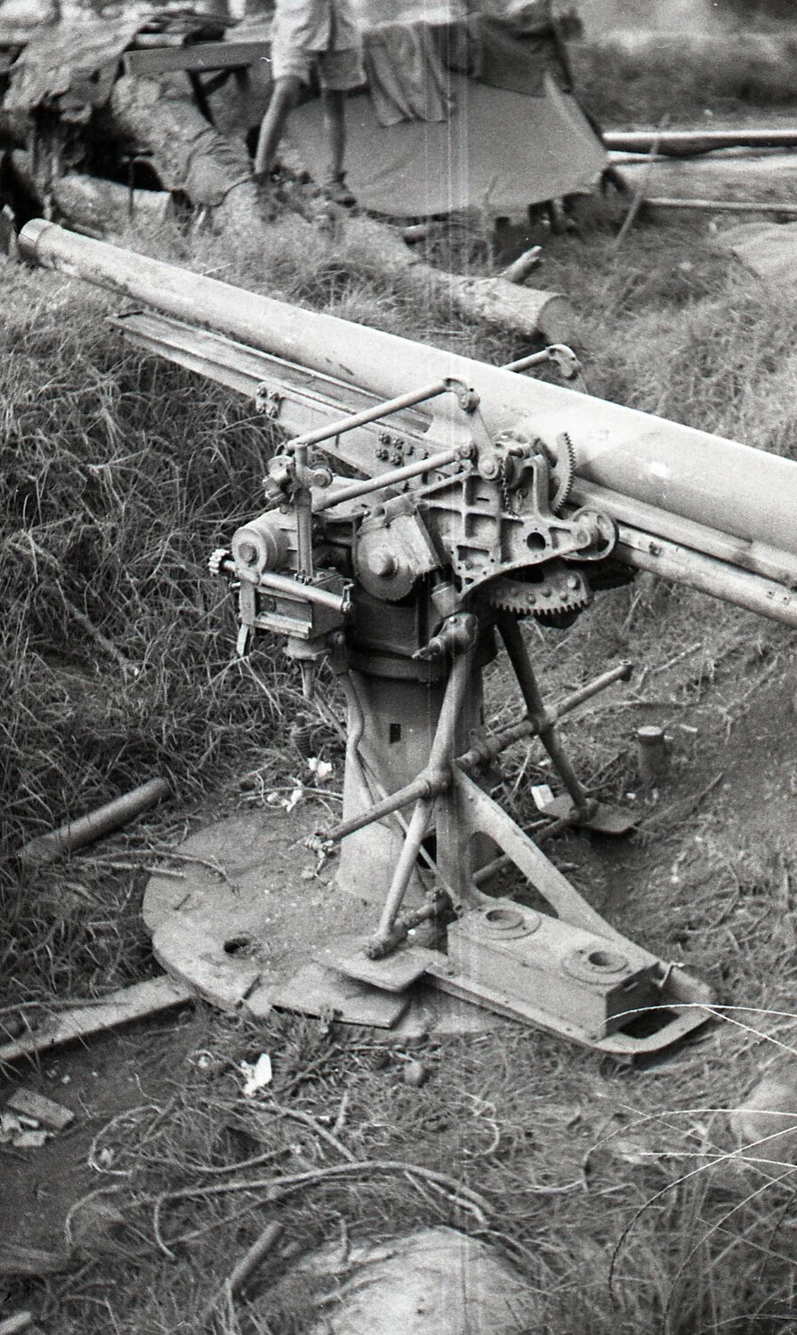 Captured Japanese Anti-Aircraft Gun Mount with American Serviceman in Background, Luzon, Philippines, WWII