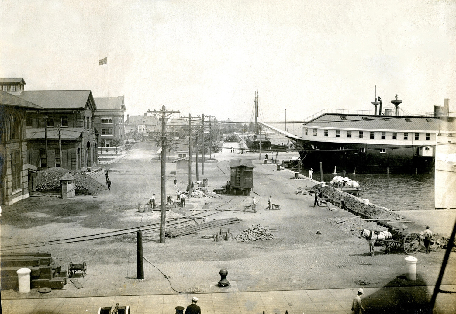 Working Waterfront Street Scene, U.S. Navy Yard (Philadelphia), with Laborers, Rail Spur, and Moored Vessel, c. 1900s