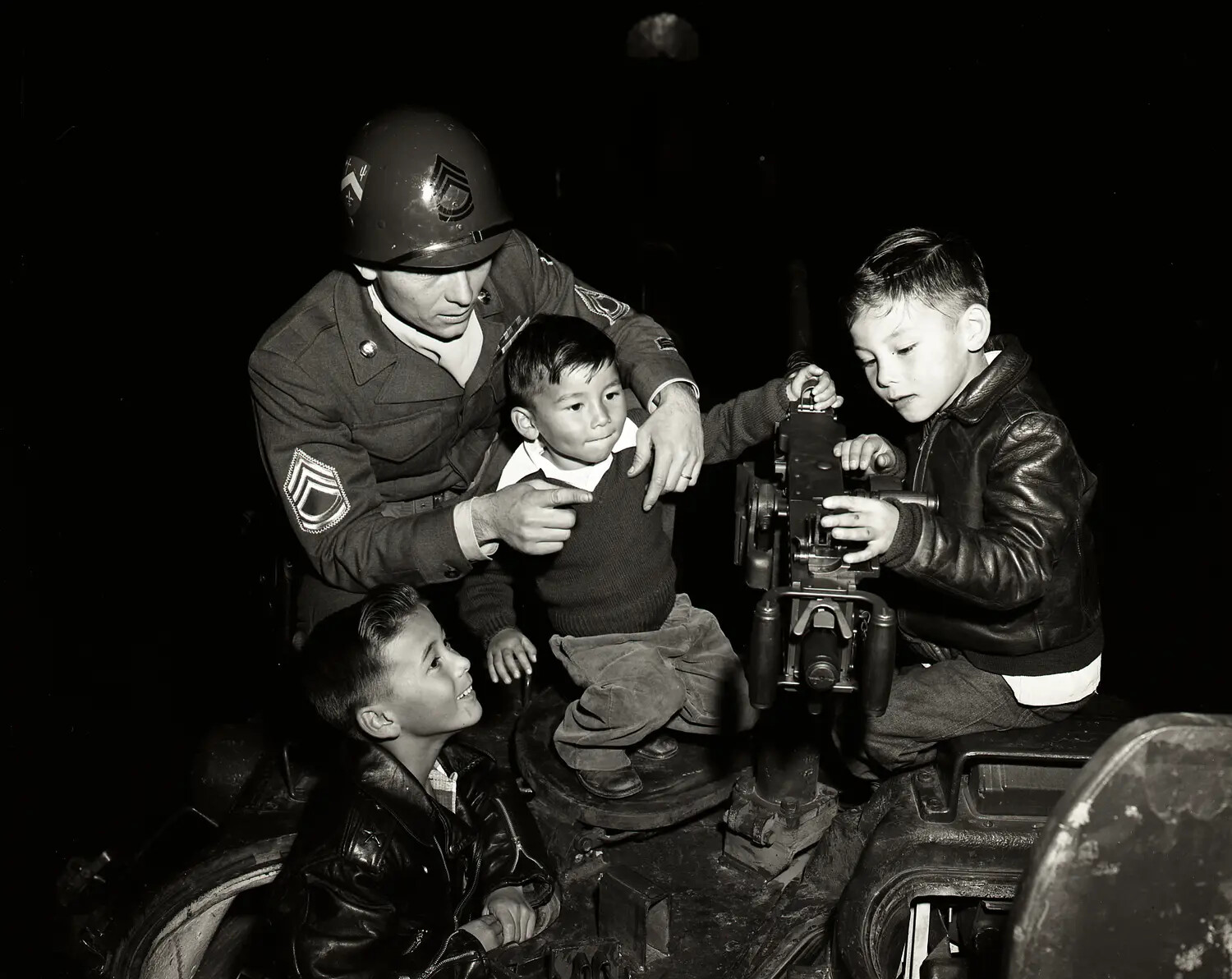 National Guard Sergeant Showing Children a .50 Caliber Machine Gun Mount on Armored Vehicle