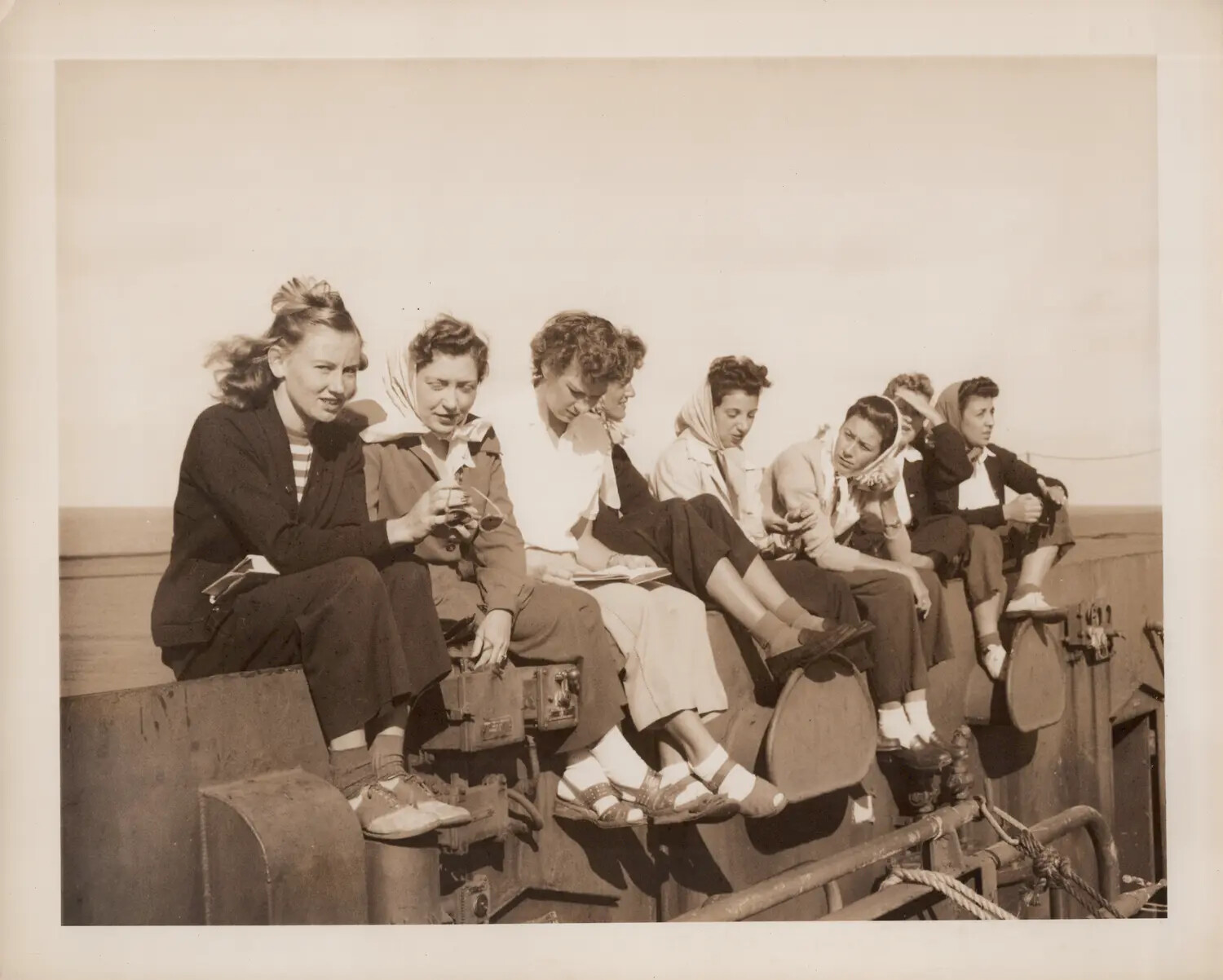 Civilian Women Seated Along Ship's Rail During Shakedown Cruise, U.S. Navy Escort Carrier, World War II