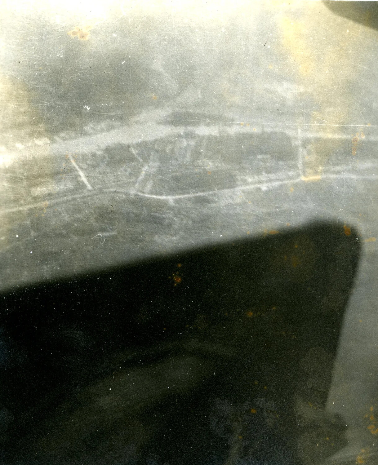 Deteriorated Aerial Photograph with Aircraft Wing/Shadow, Coastal Settlement