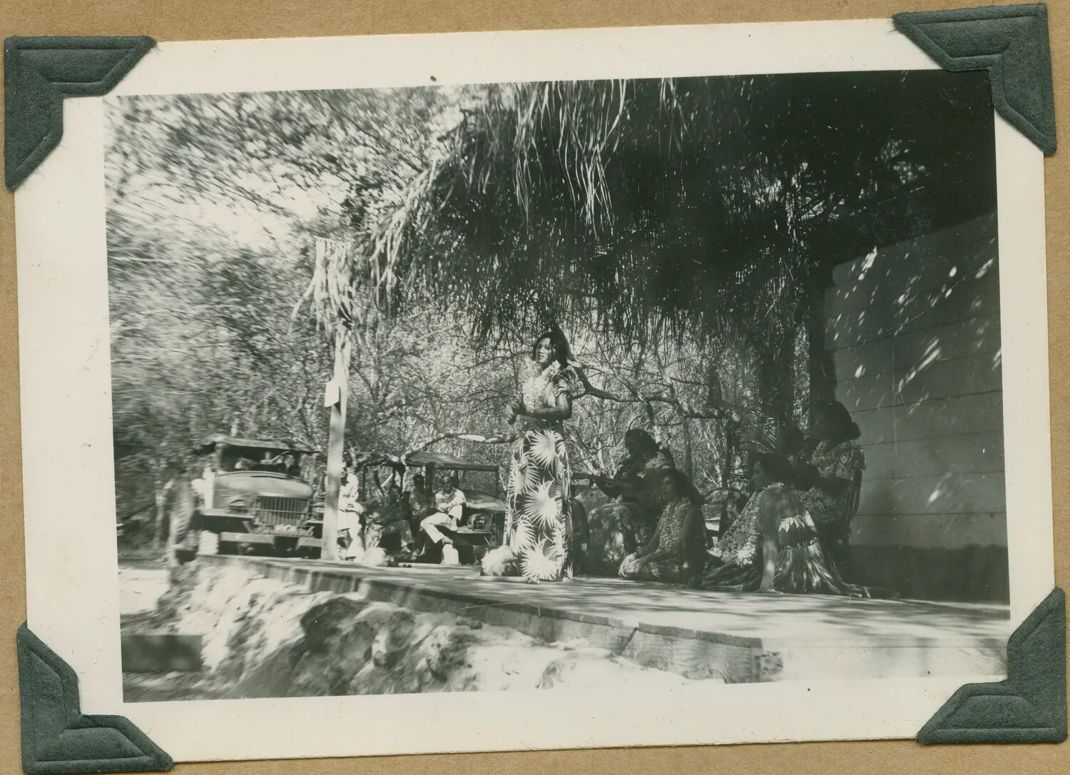WWII Hawaii Photo Album: Hawaiian Singer Performing Under Trees with Military Vehicle in Background