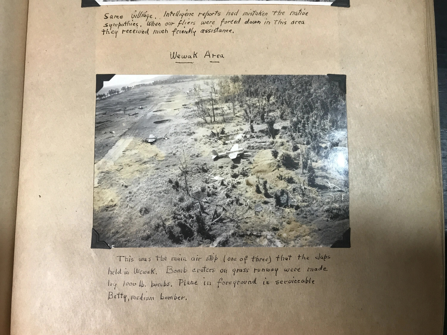 Scrapbook Page: Aerial View of Bomb-Cratered Japanese Airstrip with Derelict 'Betty' Bomber, Wewak, New Guinea