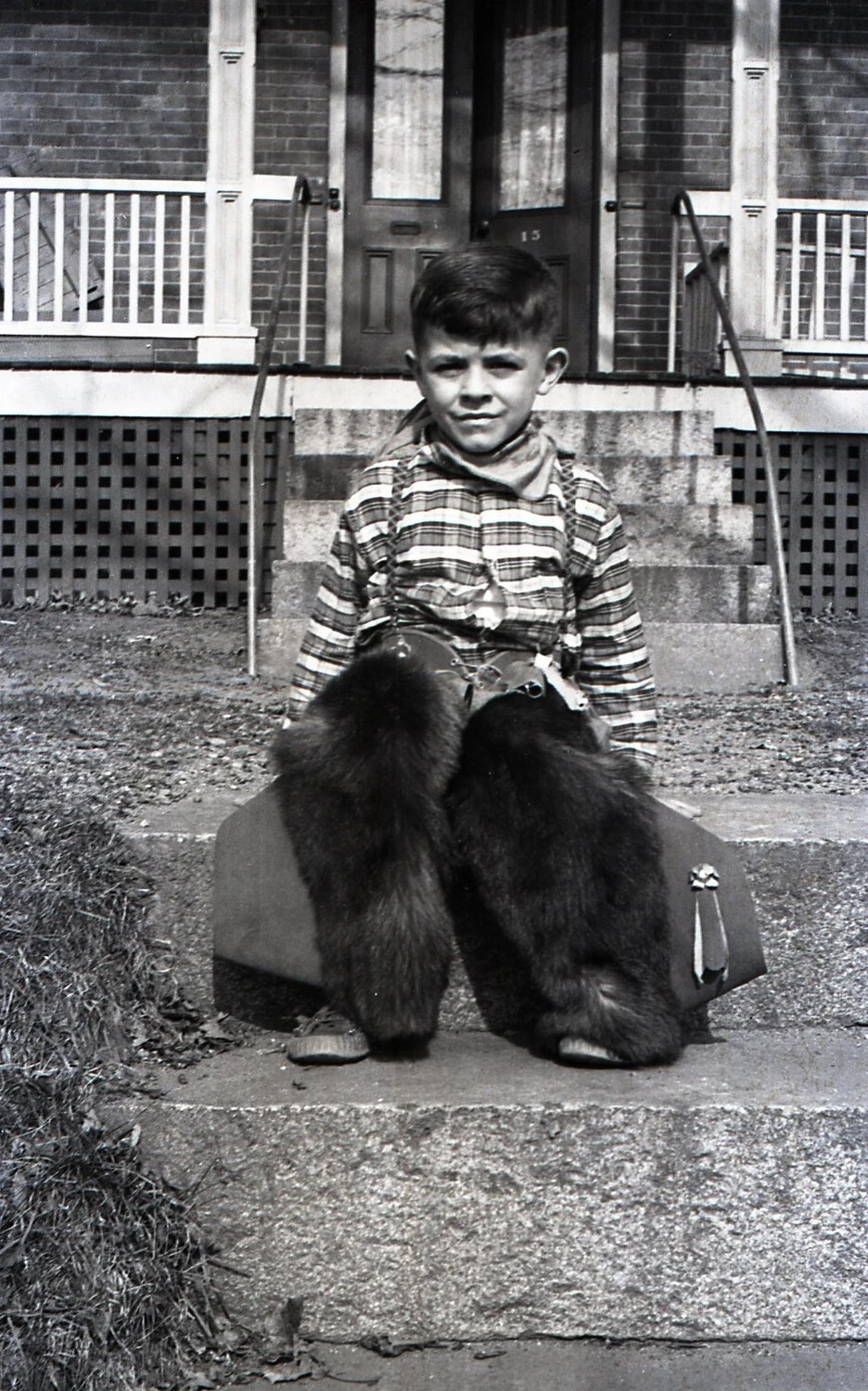 Boy in Cowboy Costume Seated on Brick Building Steps, House No. 13, c. 1940s