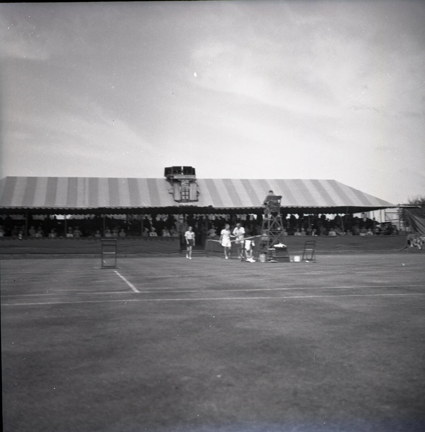 Grass Court Tennis Match with Spectator Pavilion, Possibly Featuring Bill Tilden