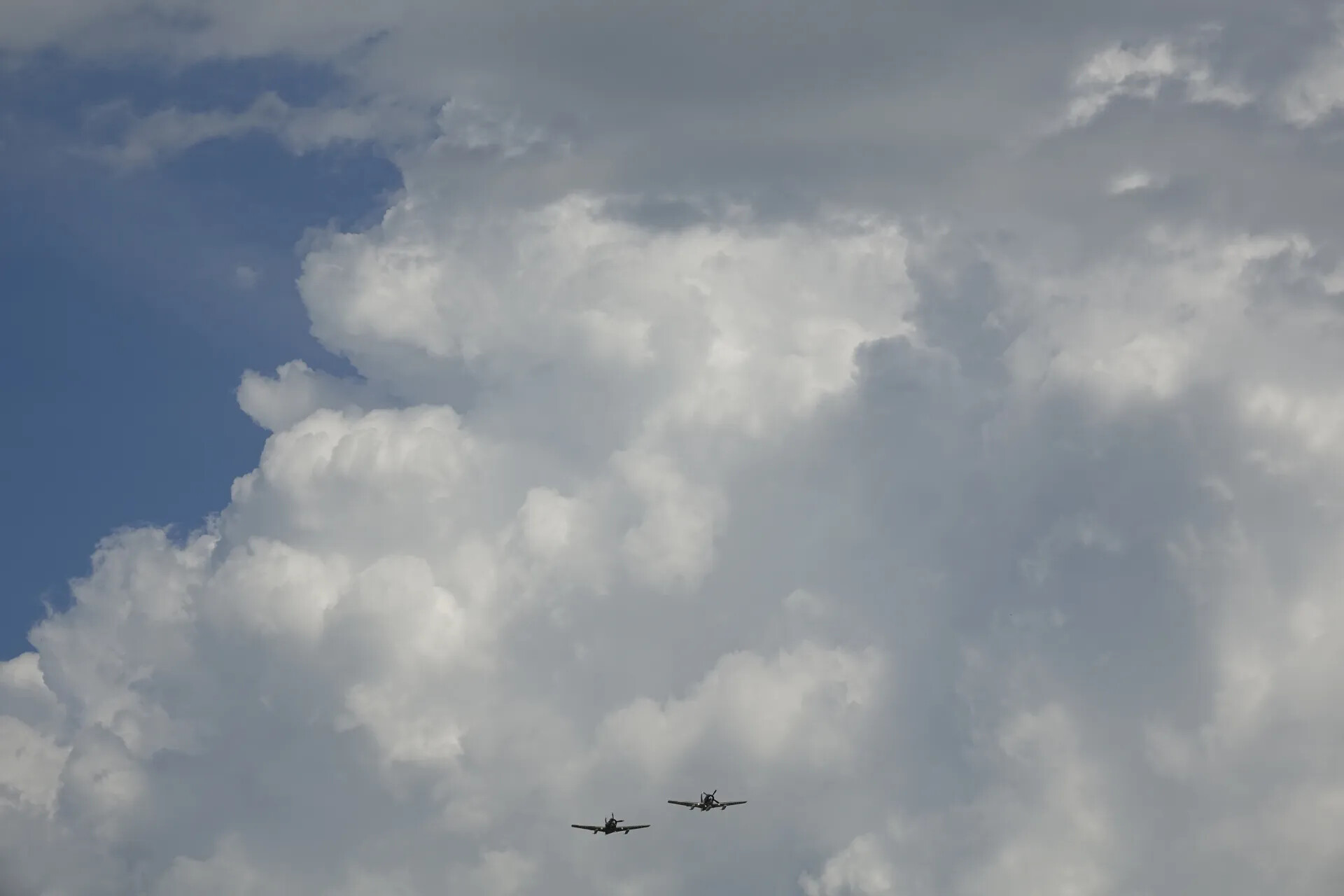 Two Propeller Warbirds in Formation Against Cumulus Clouds, May 2019 Reunion Event