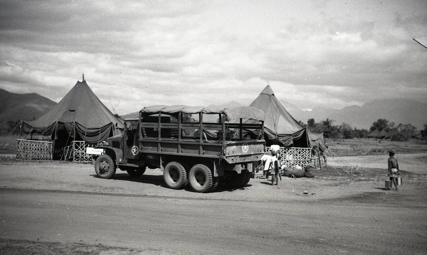 U.S. Army 6x6 Cargo Truck at Tent Camp with Filipino Civilians, Luzon, Philippines, World War II