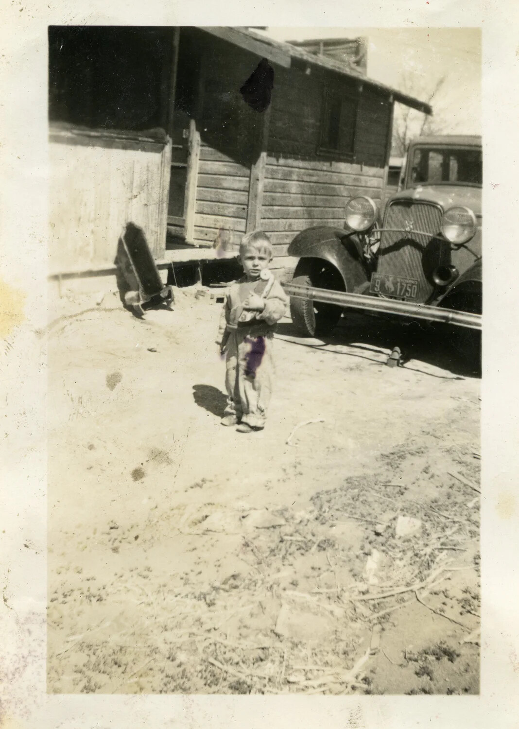 Snapshot of a Young Boy in a Farmyard with Vintage Automobile, Rural United States, Circa Mid-1930s to Early 1940s