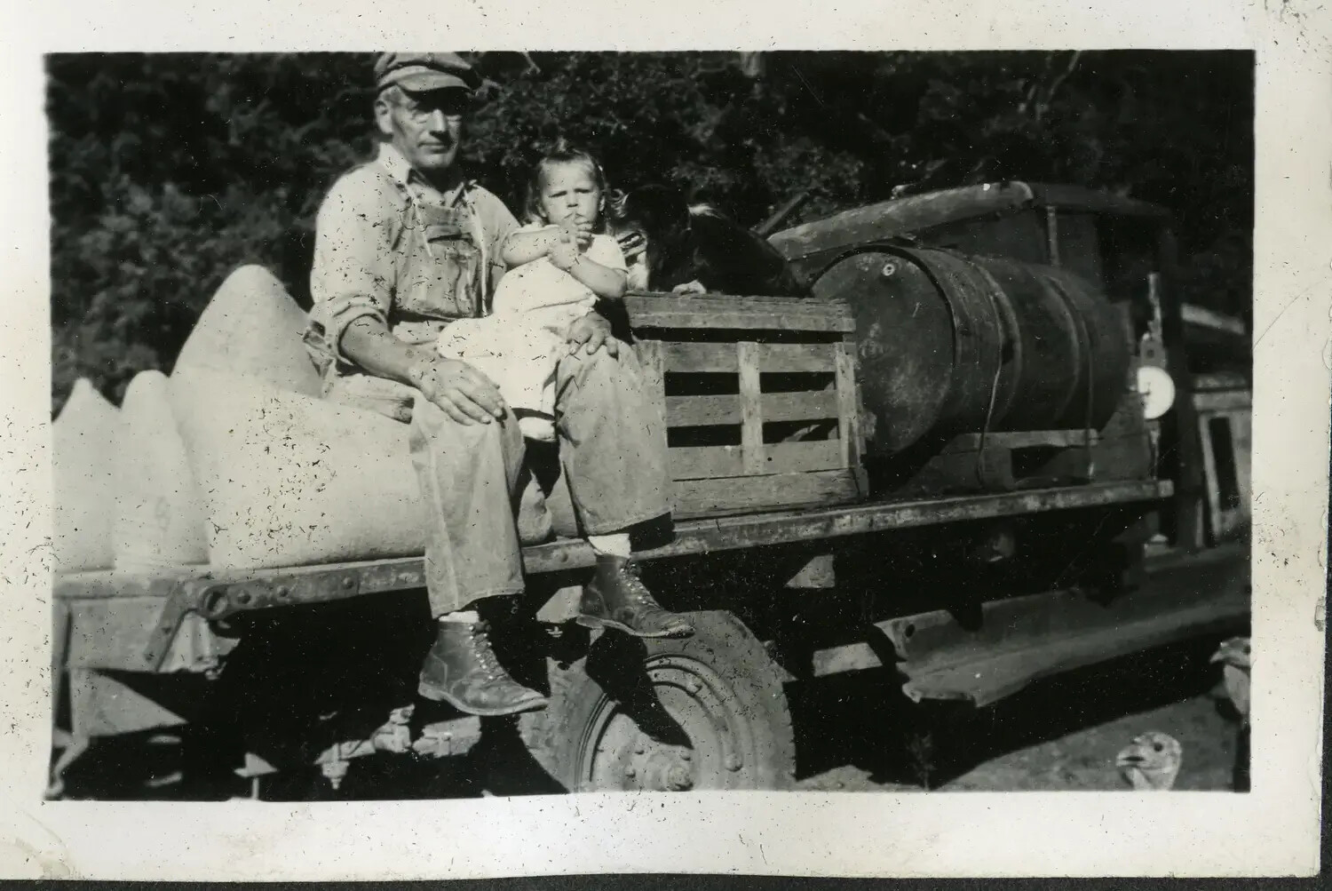 Farm Scene, Man and Child on Truck Bed — Family Snapshot within USS Maryland Photo Album, c. 1930s