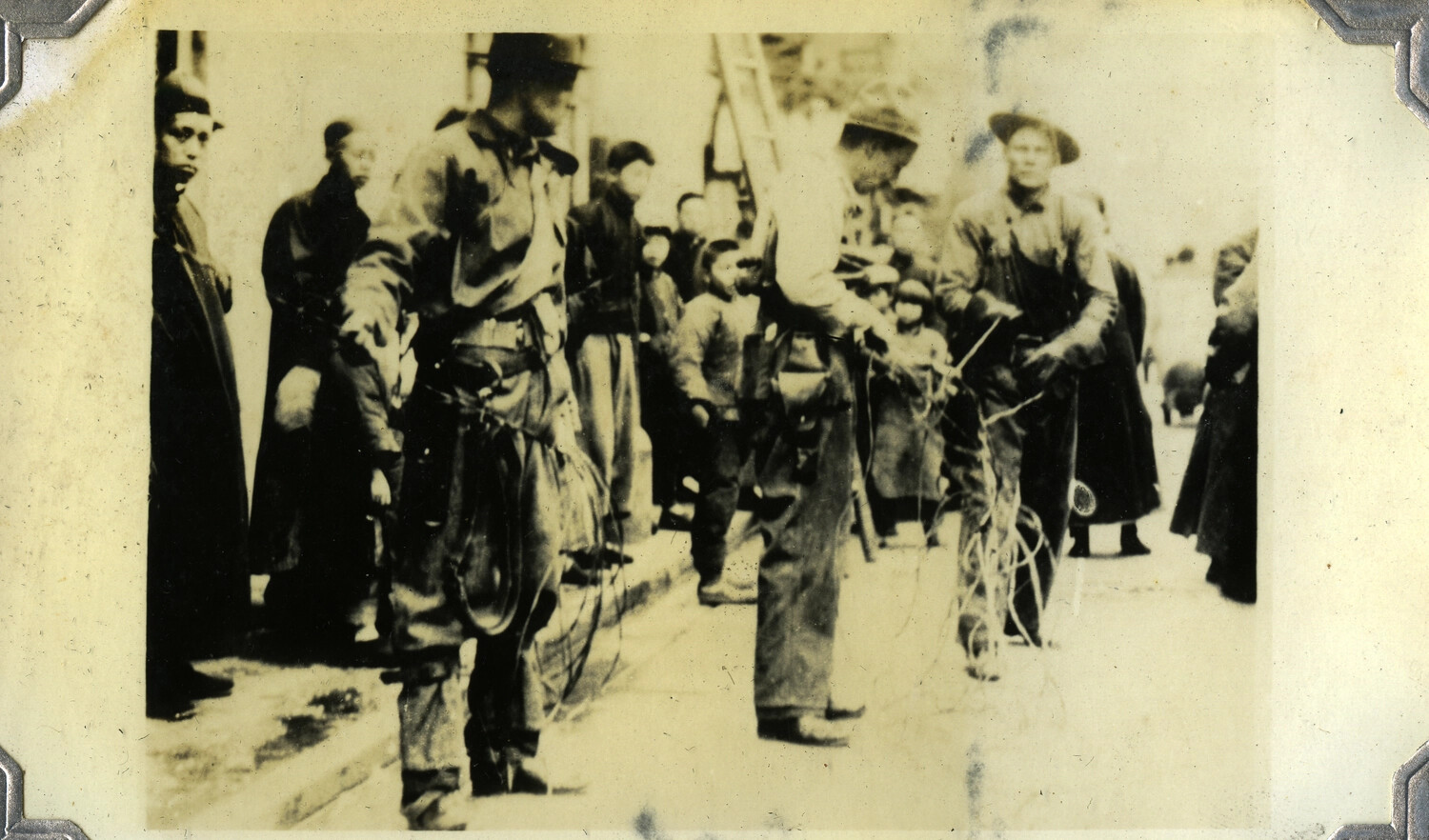 Soldiers Carrying Communication Wire Through a City Street, Watched by Local Civilians, c. 1930s