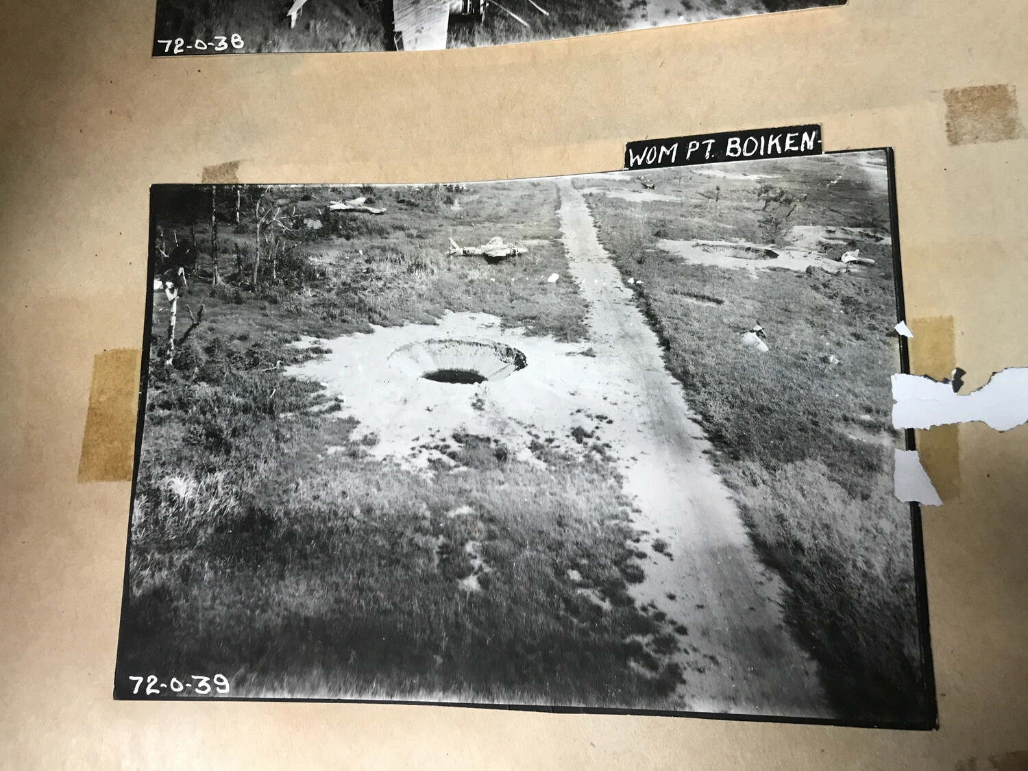 Album Page: Bomb Crater and Wrecked Aircraft at Wom Point, Boiken, New Guinea (Frame 72-0-39)