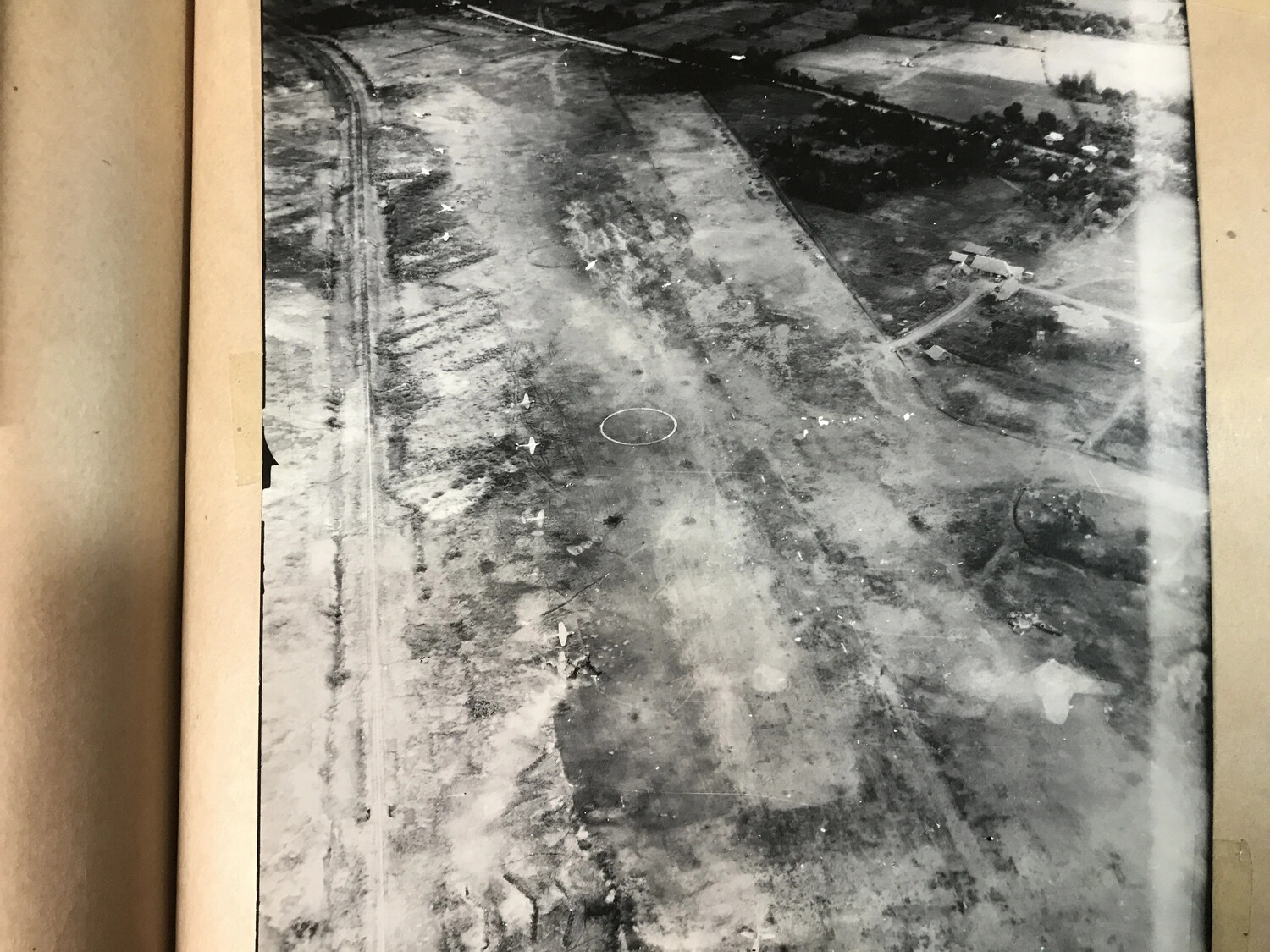 Aerial Reconnaissance Photograph of Airfield Dispersal Area with Parked Aircraft and Target Circle (Album Page View)