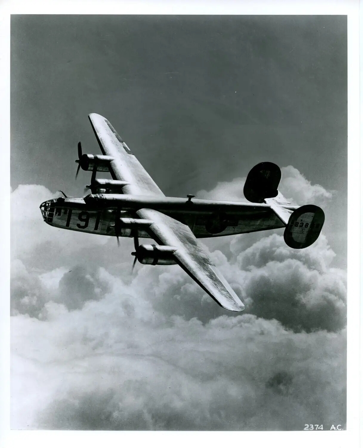 Consolidated B-24 Liberator Heavy Bomber in Banking Flight Above Clouds, Official U.S. Army Air Corps Photo No. 2374 A.C.