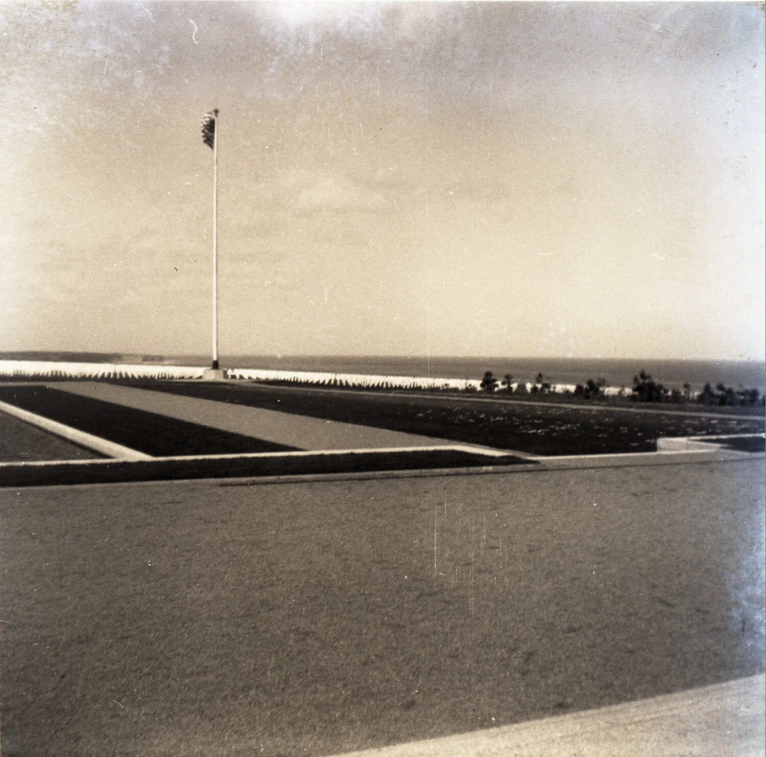Flagpole and Rows of Headstones at the Normandy American Cemetery, Omaha Beach