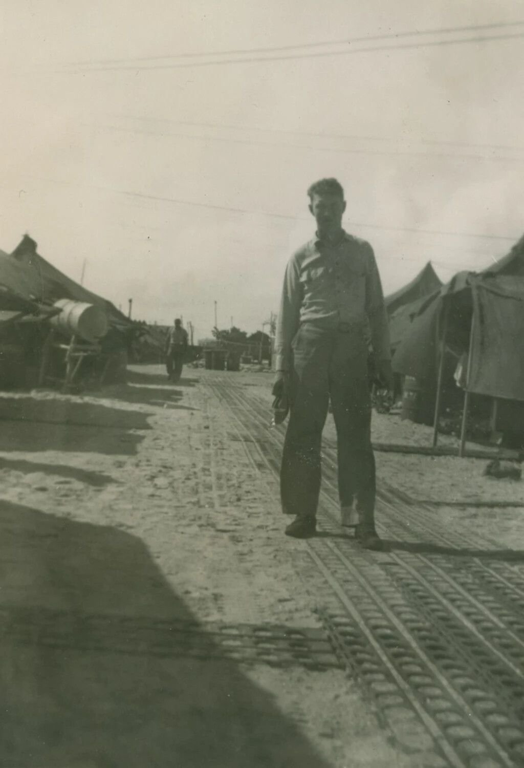 Serviceman on Marston Mat Walkway in Tent Camp, Pacific Theater