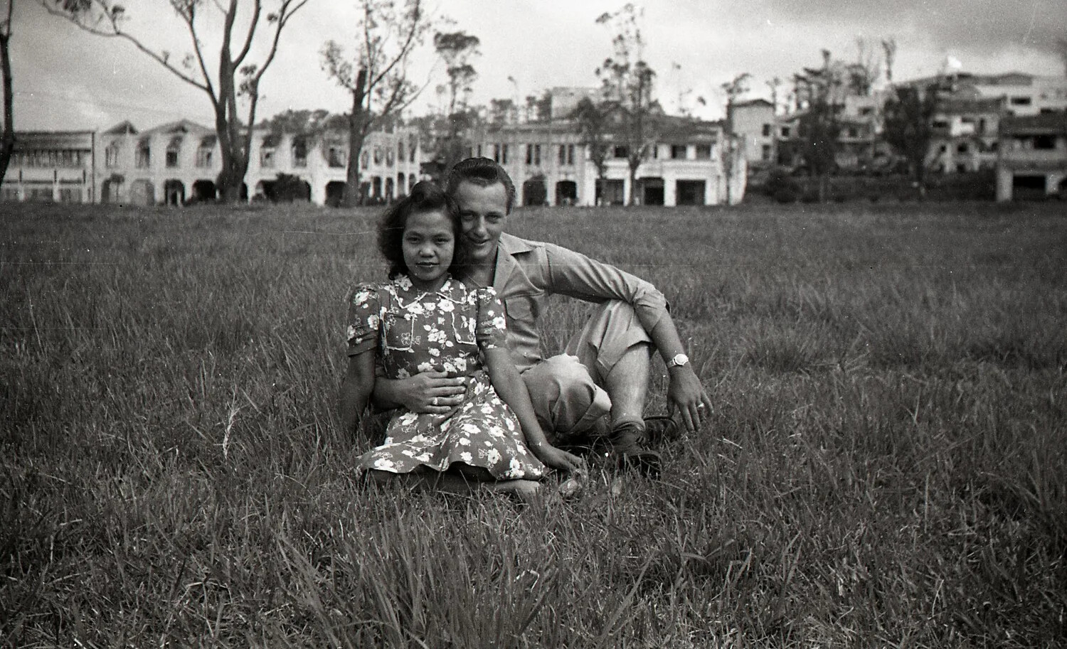 American Serviceman and Filipino Woman in Field Before War-Damaged Buildings, Luzon, Philippines, 1945