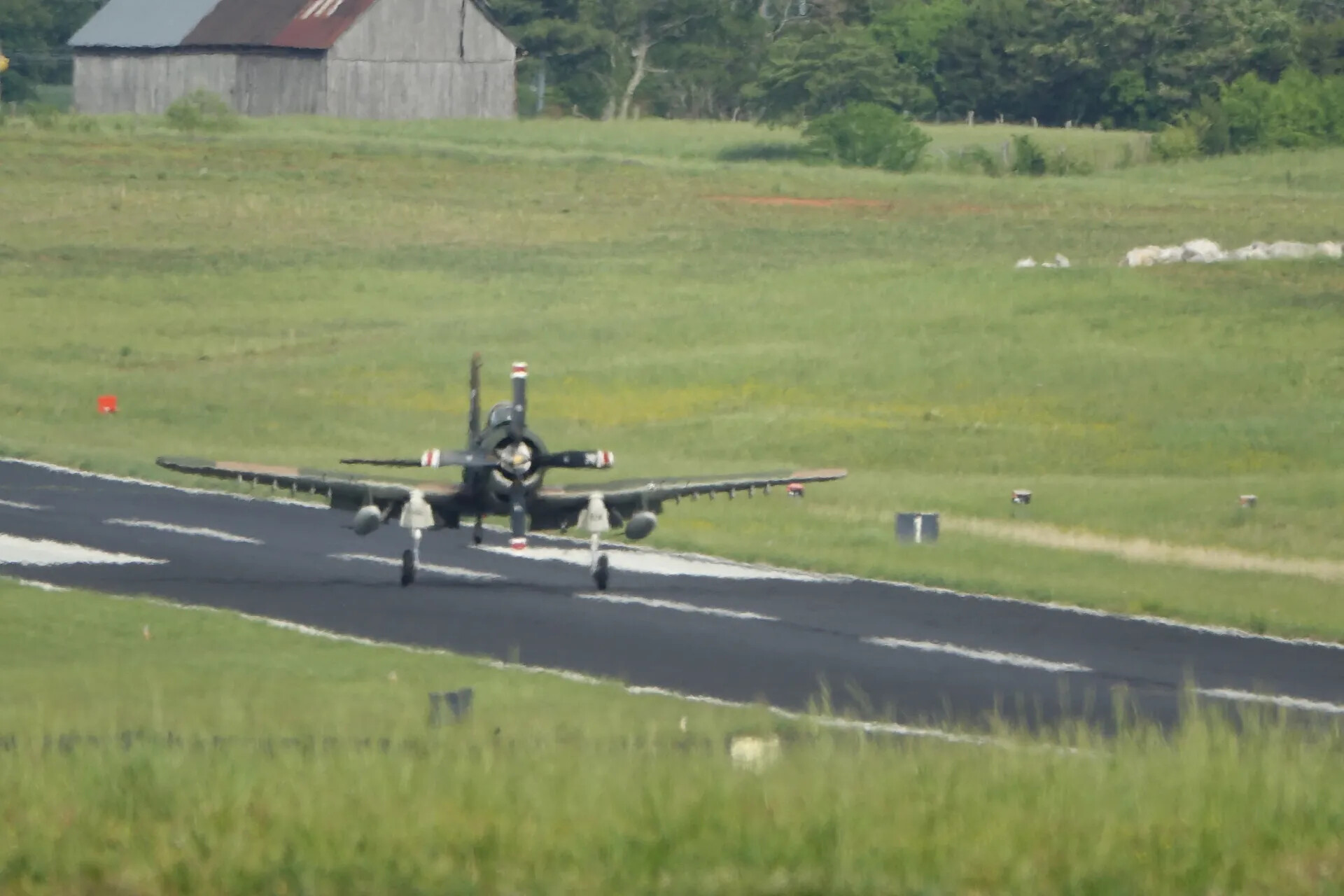 Dark-Painted Radial-Engine Warbird on Runway with Barn Backdrop, May 2019 Warbird Event