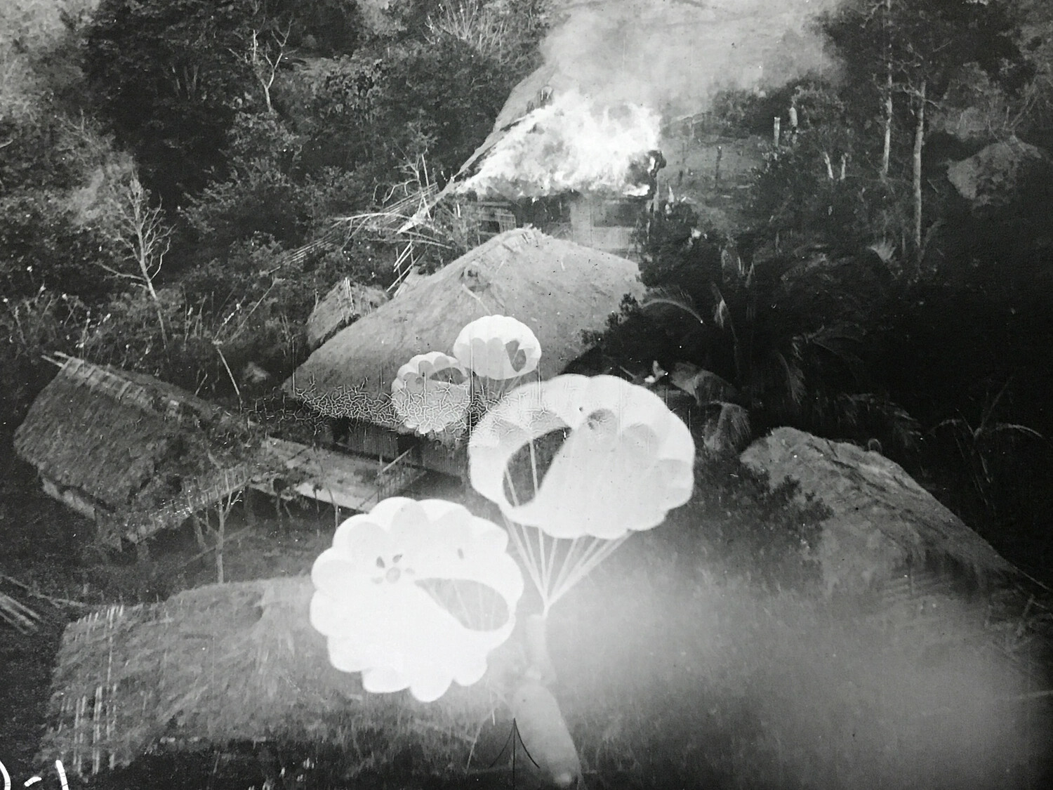 Parafrag Bomb Descending Toward Burning Village Hut, 312th Bomb Group Strike Photograph