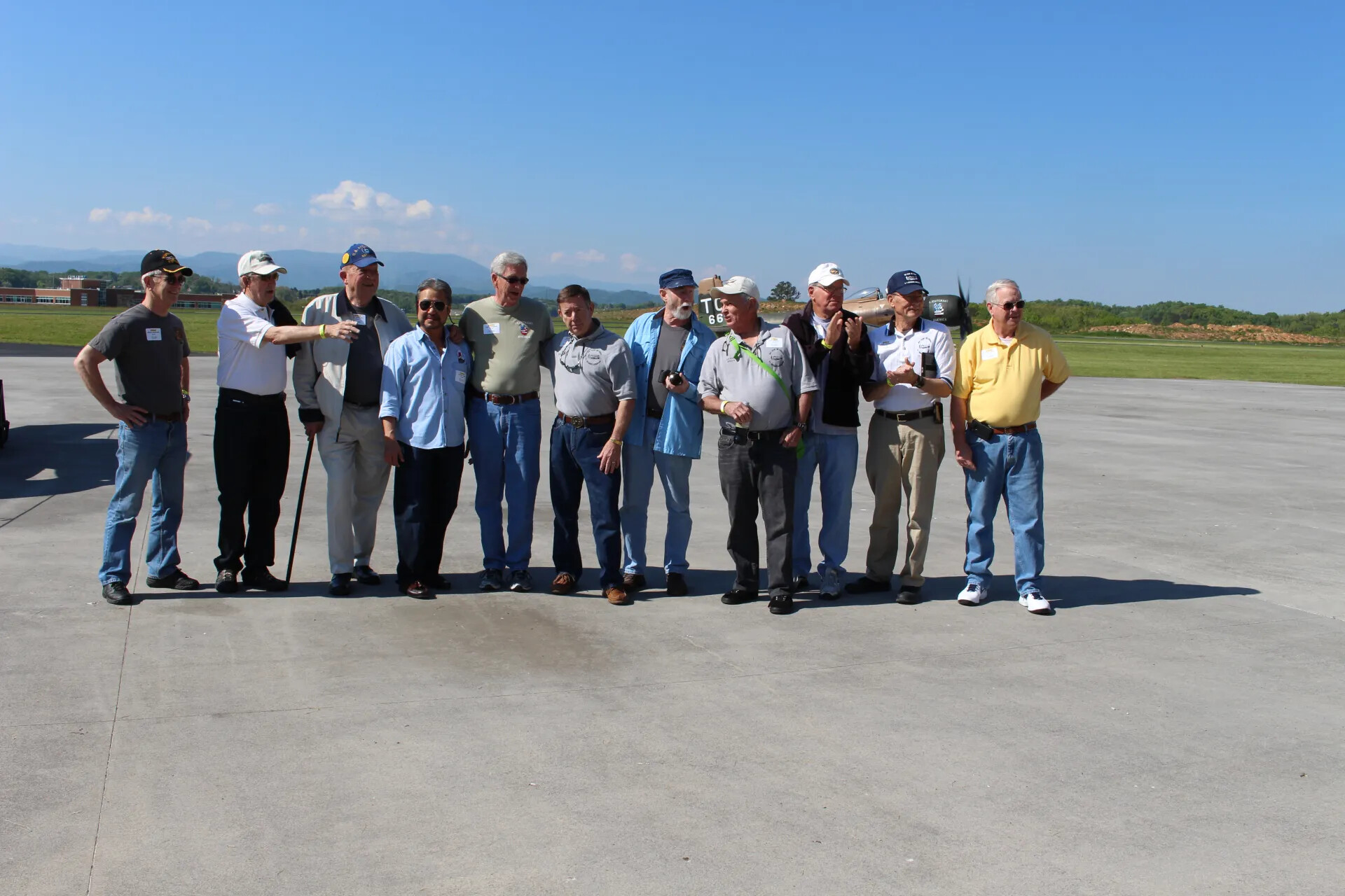 Reunion Group Photo with A-1 Skyraider "TC 665" in Background (Informal Moment)