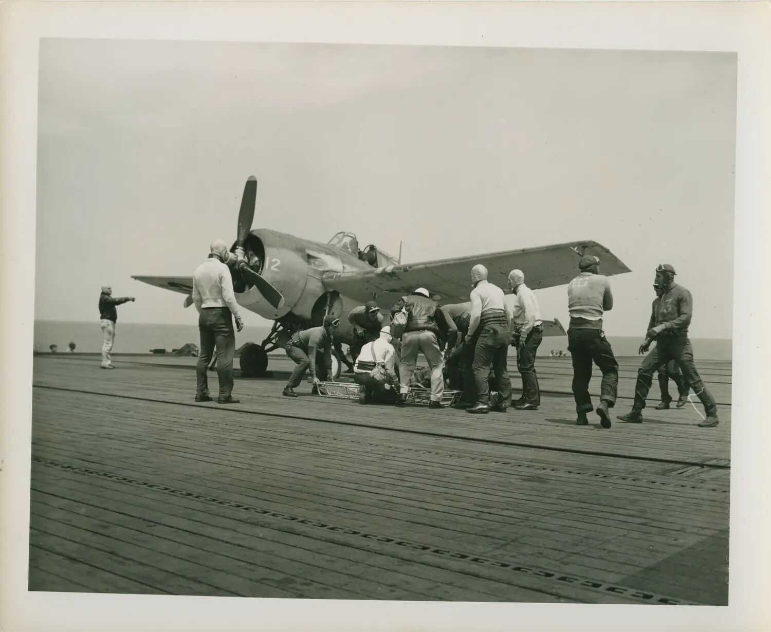 Flight Deck Crew Attending to FM-2 Wildcat Fighter Aboard USS Petrof Bay (CVE-80)