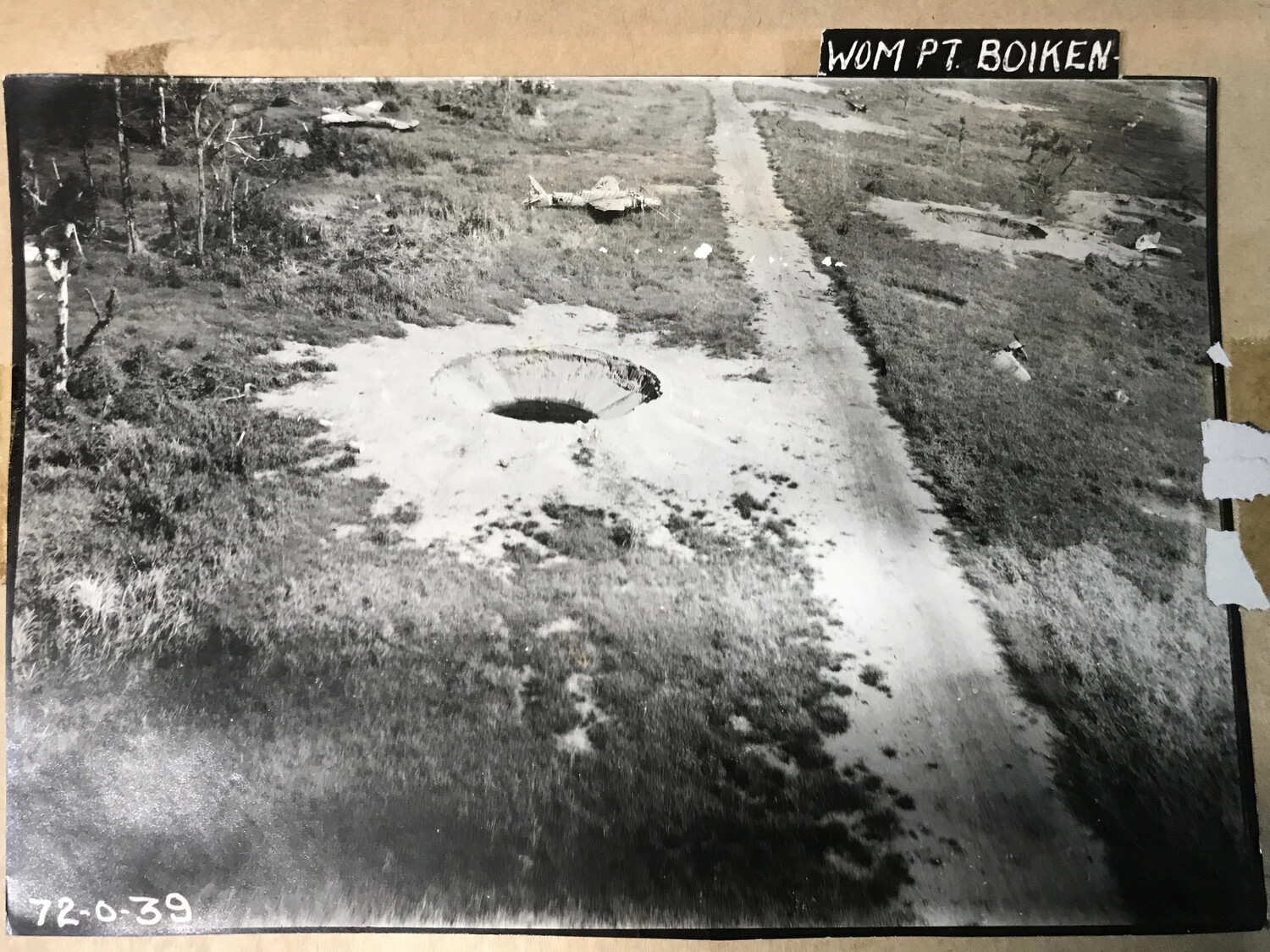 Bomb Crater and Aircraft Wreckage at Wom Point, Boiken, New Guinea (Print No. 72-0-39)