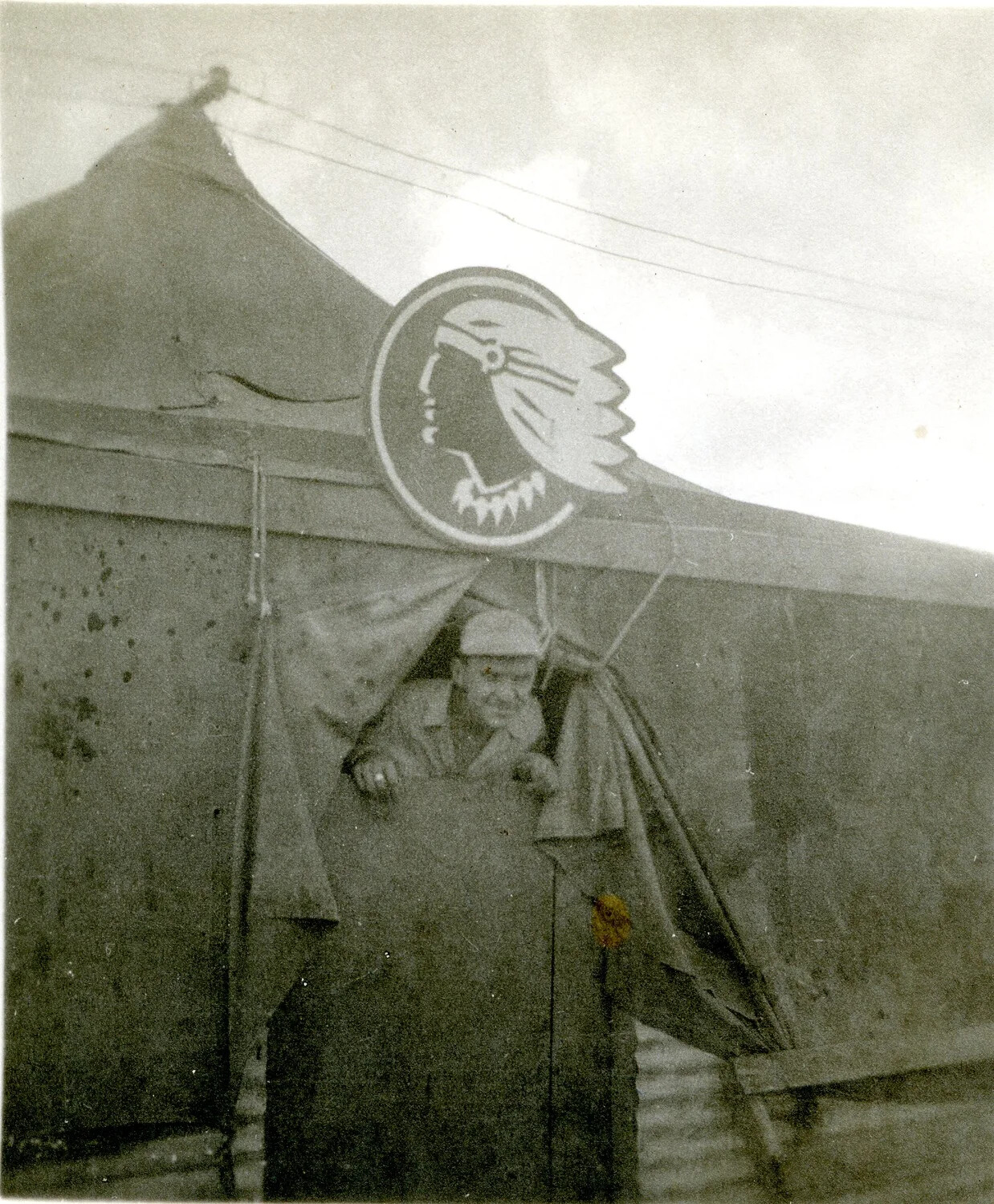 Serviceman at Tent Entrance Beneath 345th Bomb Group 'Air Apache' Insignia