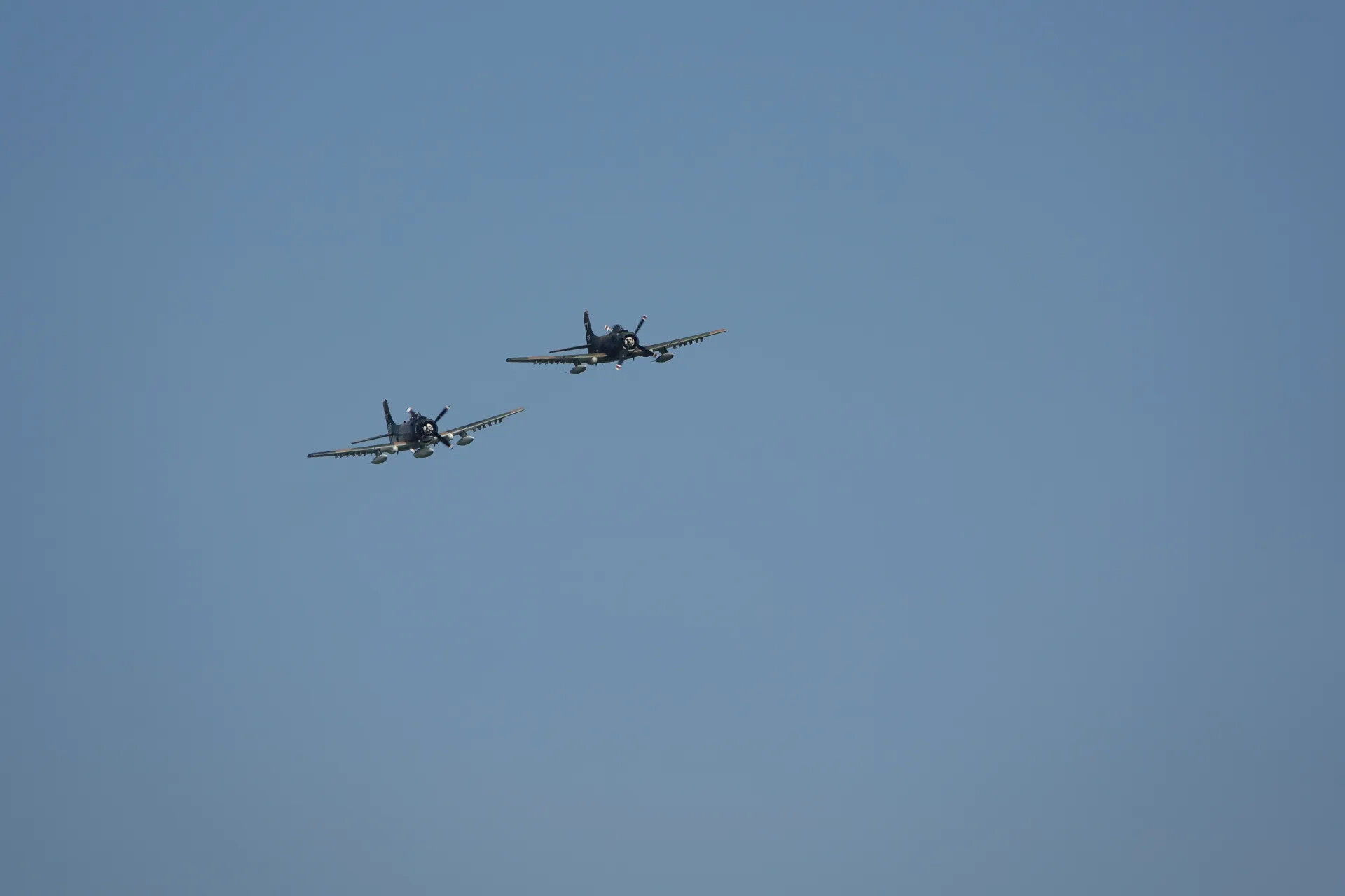 Two A-1 Skyraiders in Formation Against Clear Sky