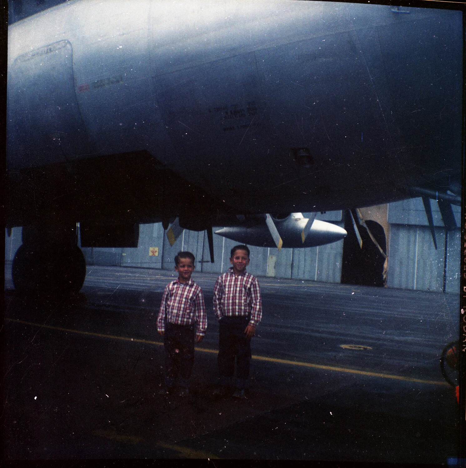Two Boys Beneath a Large Military Transport Aircraft, USAF Base (1950s-60s)