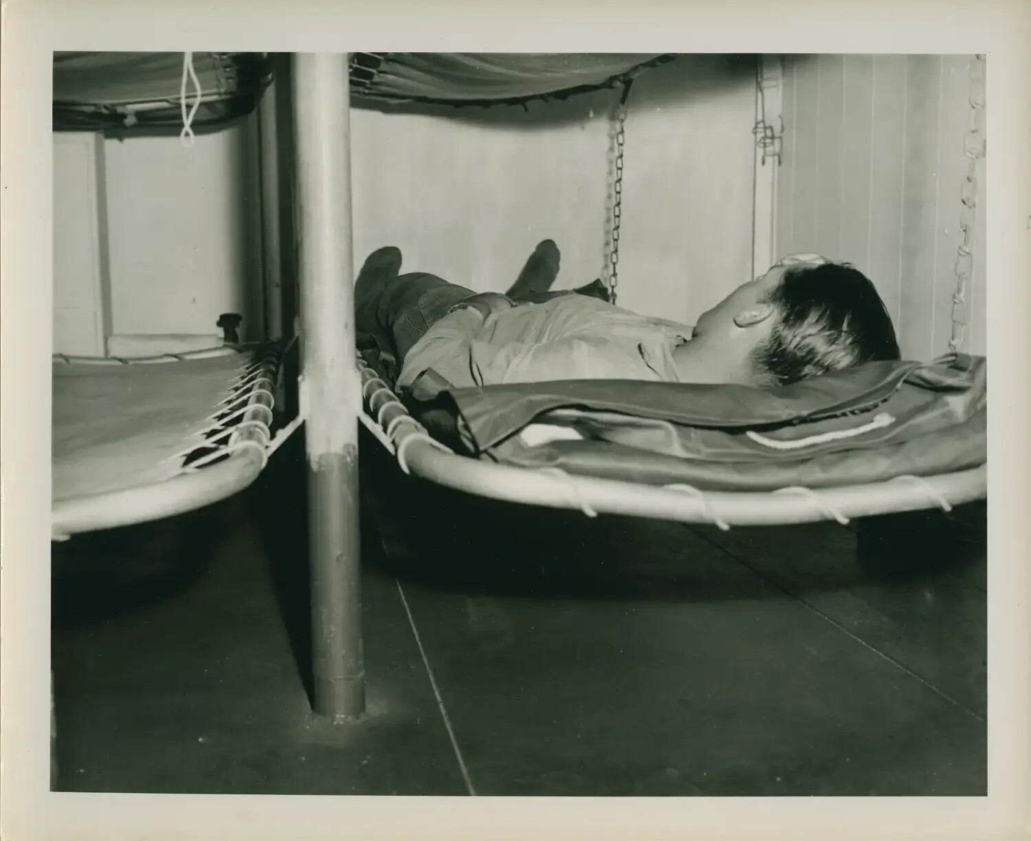 Sailor Asleep in Canvas Rack Bunk Aboard USS Petrof Bay (CVE-80)