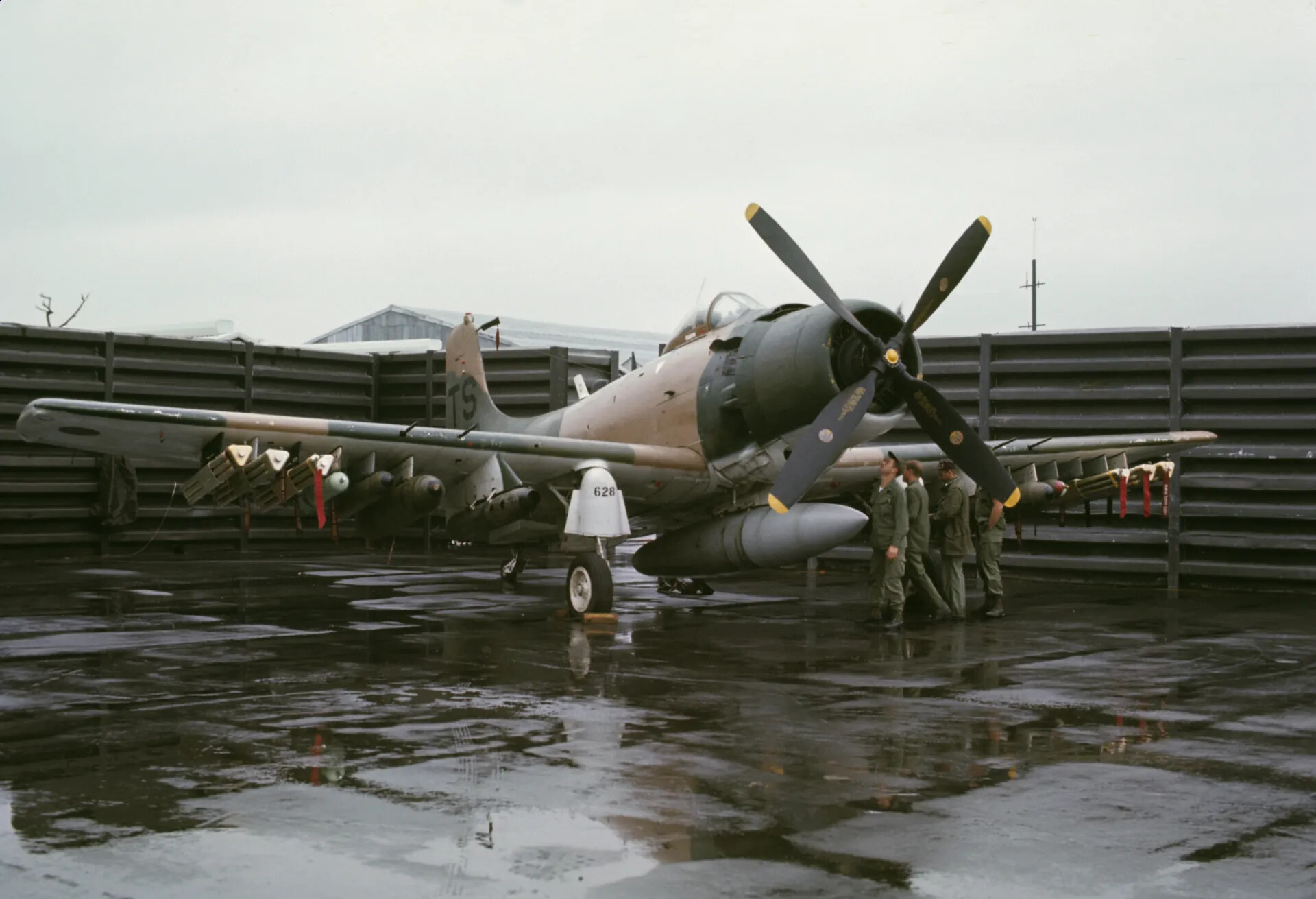 Armed Douglas A-1 Skyraider 'TS 628' on Wet Flightline with Ground Crew, Vietnam War Era