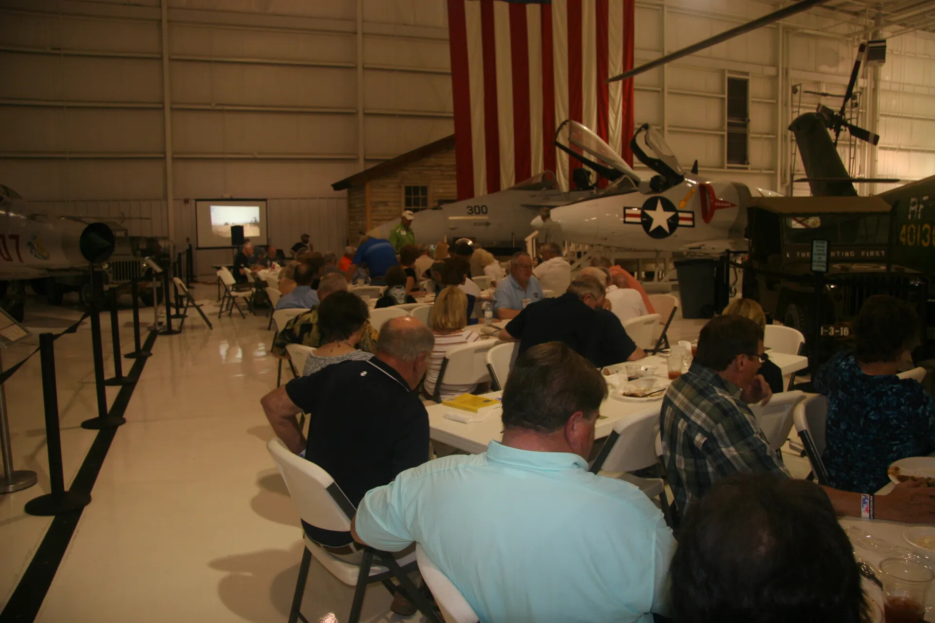 Reunion Attendees Viewing Presentation, Aviation Museum Hangar Banquet