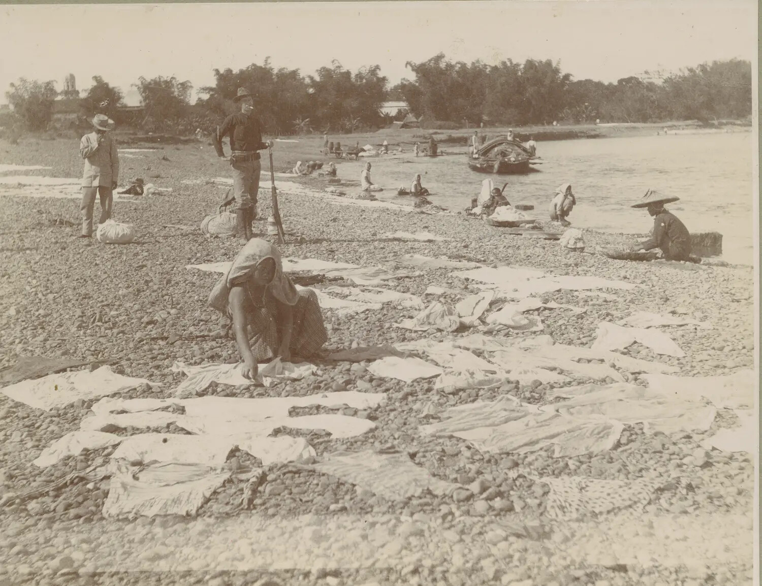 Filipino Women Washing and Drying Laundry on a Riverbank, with American Soldiers Observing, c. 1898-1902