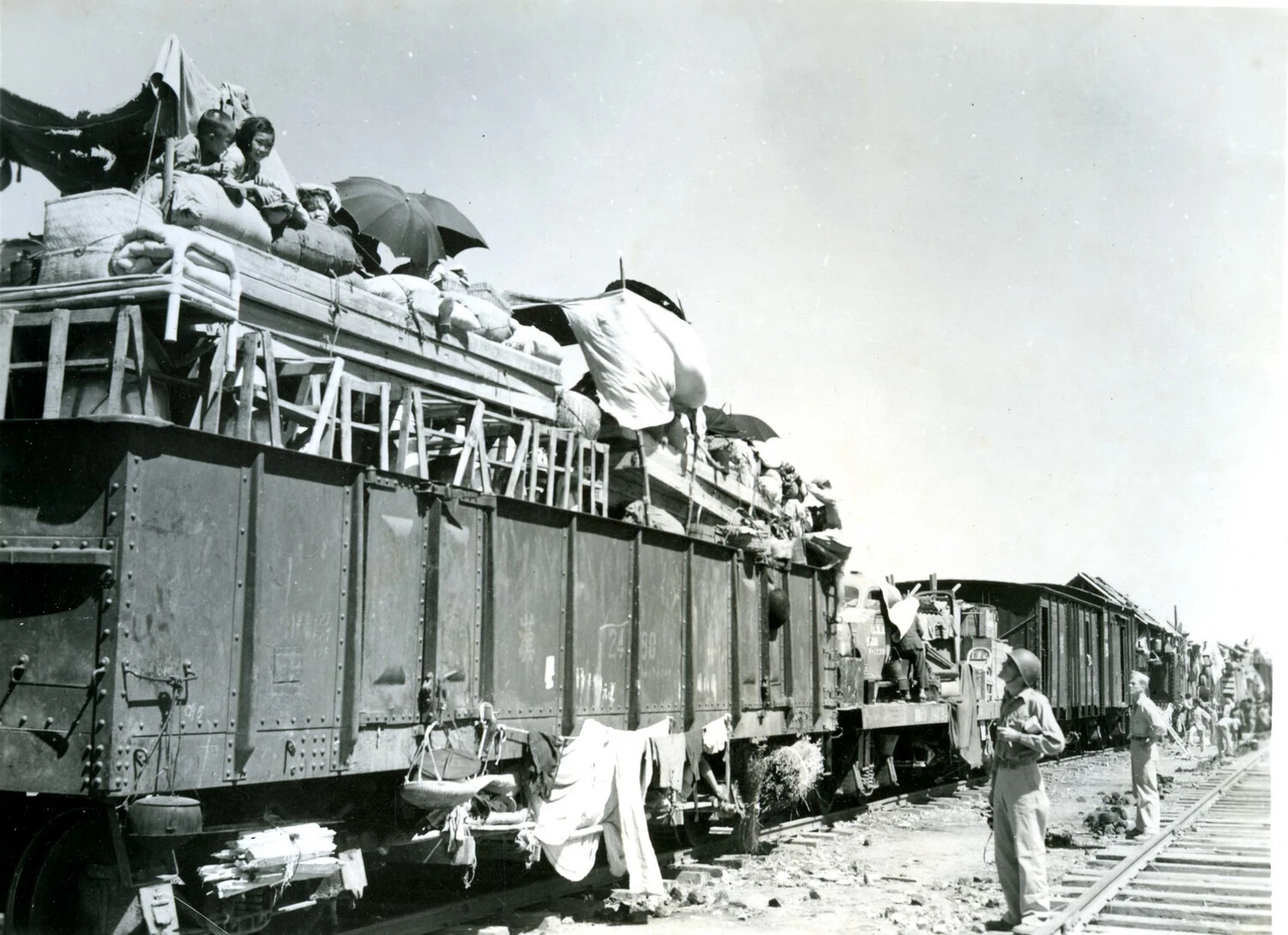 American Servicemen Observe Overloaded Refugee Train, China-Burma-India Theater, WWII Era