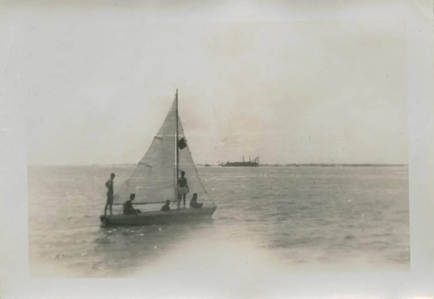 Small Sailboat with Four Passengers on Calm Water, Mid-20th Century Snapshot